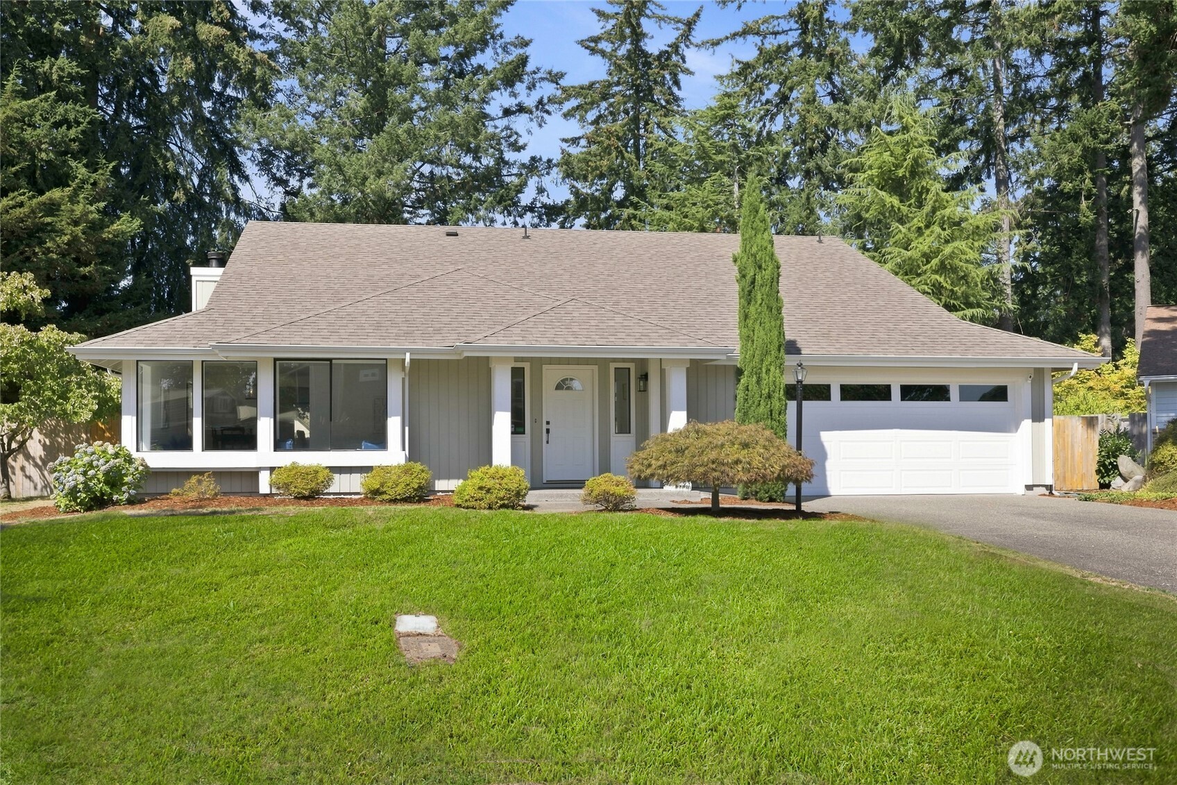 Welcome home to this remodeled 3-bedroom, 2-bath rambler which offers 1,861 sq ft of living with soaring vaulted ceilings in the main living areas. The family room centers on a brick woodburning fireplace with a slider straight out to the part shade/part sun backyard. A formal living room at the front of the home offers a sunny window nook and doubles as flex space. The kitchen, opening to the dining area, is fully remodeled with white shaker cabinetry, quartz counters with a ledge for bar stool seating, stainless steel appliances, and a subway tile backsplash with a marble look. The primary suite includes a walk-in closet and a 5-piece bath: an atrium window above the free-standing soaking tub with a ledge for plants, a double sink vanity, and a separate walk-in shower. Two additional bedrooms, an updated main bathroom, newly refinished hardwood floors, new lighting, and fresh paint throughout. A dedicated laundry room with built-in cabinetry connects the house to the garage. The lot sits on over a quarter acre, fully fenced, with a concrete patio, garden area, storage shed, and mature fir trees. A heat pump with A/C, an attached 2-car garage, and a location close to JBLM, shopping and freeways complete the package. No HOA.