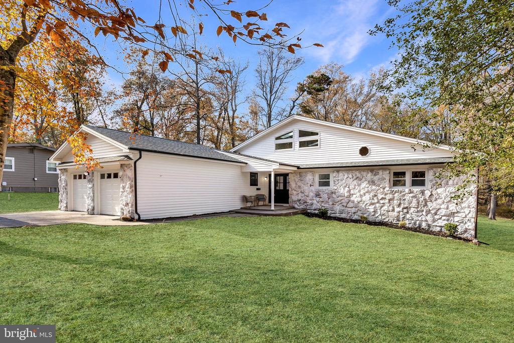 Natural Light Meets Modern Elegance. Prepare to be wowed by this stunningly reimagined 4-bedroom, 2.5-bathroom ranch with 2 car garage in the heart of Medford NJ. No detail has been spared in this top-to-bottom renovation, featuring a new roof, siding, windows, HVAC, and designer finishes throughout.The heart of the home is a massive two-story great room bathed in sunlight, thanks to a soaring ceiling, oversized picture window and 10+ skylights. The open-concept layout flows seamlessly into a chef’s dream kitchen, complete with custom cabinetry, crisp white quartz countertops, a feature wine rack, and premium stainless steel appliances. Retreat to the owner’s suite, which offers private backyard access and a spa-like ensuite featuring an oversized custom tile shower and a deep soaking tub. Outside, your private oasis awaits: a cleared, graded lot backing up to a tranquil, winding stream. With every major system updated and aesthetic perfection achieved, the only thing left to do is move in. With an acceptable offer seller would be willing to convert the 3 sets of steps to a deck.