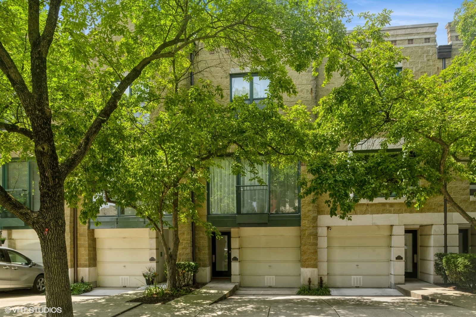 Meticulously maintained & beautifully upgraded townhome on a picturesque tree-lined street in award-winning Lincoln School District. This 3 Bed/3 Full Bath Larrabee Commons home has private outdoor space and private attached garage parking wired for EV charging. More than 2,300 sq.ft. of open concept living with room for a large dining room table and spacious entertaining complete with a wood-burning fireplace. Beautiful hardwood floors and stone throughout, with custom motorized roller shades.  Stainless steel Kitchen Aid and LG Appliances alongside waterfall quartz countertops complete the eat-in kitchen that overlooks a professionally manicured & gated courtyard. Primary suite has a full wall of custom-built closets and views of John Hancock Center. Bathe in natural skylight in the (2025) designer primary ensuite that features double sinks, a walk-in shower and modern luxuries like back-lit mirrors and Bluetooth-enabled lighting. 2nd bedroom includes a full wall of custom closets and overlooks the landscaped courtyard. A full 2nd bath, (2025) front loading washer and dryer, and beautiful stairwell skylight complete the top floor. The 3rd bedroom is on the main floor and has a full attached bath & access to the large private patio. Private attached garage has additional storage plus exterior driveway parking for 1 car. (2024) Furnace, (2019) Water Heater, & (2021) A/C Condenser serviced annually. Professionally managed by First Service Residential, assessment includes Xfinity Package with HBO/Showtime and Full Blast Internet. No planned specials. (2025) Repainting of private patio wrought iron fencing & gates to be paid from well-funded reserves. (2023) New roof. Premier A+ location, blocks to Oz Park and Bauler Park, CTA Red and Brown/Purple line stations, Lincoln Park Farmers Market, Lake Michigan, Second City and all the dining and entertaining options that Wells Street has to offer. Pet & investor friendly with no rental cap (minimum 1 year lease).