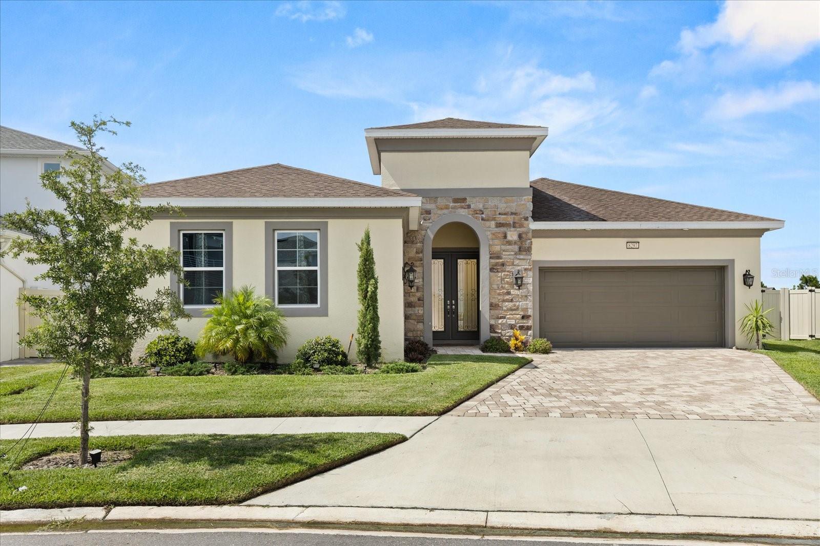 **This property qualifies for a closing cost credit up to $12,000 through the Seller’s preferred lender (restrictions apply).** Welcome to a beautifully designed 4-bedroom, 3.5-bathroom single-family home that blends elegance, comfort, and modern living. Located in the sought-after community of Epperson Wesley Chapel, this residence offers impressive curb appeal with a manicured front yard, a paver driveway, and a 2-car garage. A beautiful stone façade frames the arched passthrough leading to French wood-framed glass doors, setting a warm and inviting tone. Step through into your private lanai, where a sparkling pool awaits—surrounded by a spacious paver patio, perfect for relaxing or entertaining. The patio is also plumbed and ready for a custom outdoor kitchen, making it an entertainer’s dream. Inside, the open-concept layout seamlessly connects the kitchen, dining, and living areas. The living room is anchored by a sleek black modern ceiling fan and a large four-pane sliding glass door offering a stunning view of the pool area. Modern square accent windows adorn the wall above the dining space, adding natural light and architectural interest. The chef’s kitchen is upgraded throughout and features a striking white waterfall stone island with breakfast bar seating, modern pendant lighting, stainless steel appliances, a sleek cooktop with a matching range hood, built-in oven, pristine white cabinetry, and an upgraded backsplash that adds a stylish, polished finish. Adjacent is a well-equipped laundry room with a bottom-loading washer and dryer, plus built-in shelving for convenience. Down the hall, two carpeted bedrooms with built-in closets and stylish black ceiling fans share a thoughtfully designed Jack-and-Jill bathroom with dual vanities and a tub, all tied together with the same upscale cabinetry from the kitchen. A nearby half bath offers additional comfort for guests. The spacious carpeted primary suite is a true retreat, boasting tray ceilings, signature square windows, and a triple-pane sliding door that opens directly to the pool and patio area. The ensuite bathroom includes dual sinks, a large mirror, matching cabinetry, and a luxurious glass-enclosed, oversized tile shower with an overhead rainfall showerhead. All bathrooms in the home have been thoughtfully upgraded for a modern, high-end feel. The fourth bedroom serves as a private in-law suite located at the front of the home—offering privacy and versatility with its own full bathroom, making it ideal for extended family, guests, or a home office setup. Step outside to the covered patio, ideal for outdoor lounging or dining. The serene pool includes a small waterfall feature and is fenced for added privacy. Beyond the pool, a fully fenced blank canvas backyard invites your imagination—perfect for a garden, play space, or custom outdoor oasis. Don’t miss your chance to own this move-in-ready gem that perfectly balances style and functionality in a thriving location! ** Furniture negotiable**