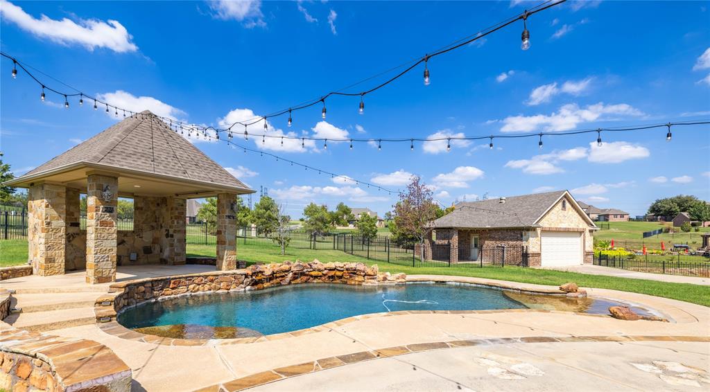 Discover this exceptional custom built 4-bedroom, 2.5-bath home featuring a fully equipped detached ADU with its own kitchen, bathroom, and laundry—ideal as a mother-in-law suite, private guest quarters, or home office—set on just over an acre of beautifully landscaped land. The bright and open floor plan boasts abundant windows that flood the space with natural light, creating an inviting atmosphere throughout. Inside, enjoy two spacious living areas, two dining areas, a private study, and a striking stone double-sided fireplace connecting the main living room and large bonus room. Upstairs, the fourth bedroom is an ideal kids’ retreat, teenager’s hideaway, or media room. The primary suite offers a spa-like bathroom with a jetted tub, walk-in shower, and a large closet with built-in storage—your perfect personal retreat. The bonus room includes generous storage and an attached half bath with direct backyard access, great for poolside convenience. The chef’s kitchen shines with abundant counter space and storage, flowing seamlessly into both dining areas for everyday living and entertaining. Step outside to your private backyard paradise featuring a custom pool with natural stone accents and a tranquil water feature, a large covered patio, cozy fire pit, and elegant stone cabana—designed for year-round enjoyment. Complete with a 3-car garage and versatile floor plan, this home offers the perfect blend of luxury, space, and lifestyle. Located in the prestigious gated Harbour View Estates, just minutes from Eagle Mountain Lake, residents enjoy access to community amenities including a community pool, walking trails, and playground, with easy access to highways and shopping for added convenience.