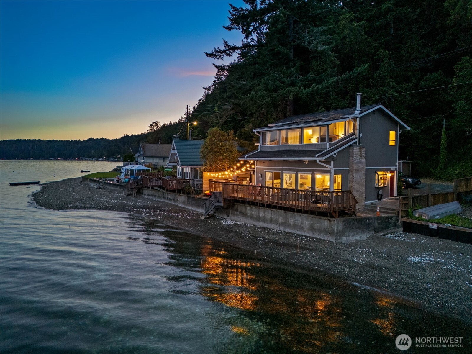 Your Hood Canal paradise awaits! Set at the water’s edge with 50 feet of bulkheaded waterfront, this home offers stunning canal views from nearly every room. The open-concept layout features an updated kitchen, dining area, and inviting living room with a cozy wood stove. One bedroom and bath are on the main level, while upstairs you’ll find the primary suite with a sunroom overlooking the water—perfect for year-round relaxation or additional guest space.With a new roof, recent updates, negotiable furnishings, and a proven history as a successful Airbnb, this is the ideal getaway or investment opportunity. Relax, entertain, and play just steps from your private beach. Your own beach house, just in time for summer!