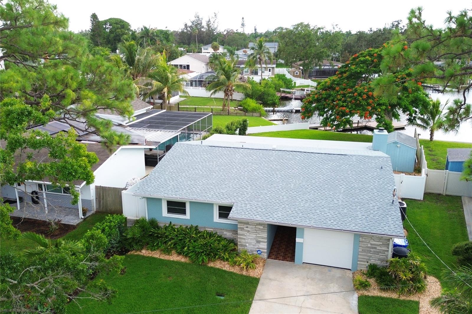 On a waterfront lot with direct access to Tampa Bay, this meticulously renovated residence offers nearly 2,000 square feet of thoughtfully designed living space in one of St. Petersburg’s desirable neighborhoods. Featuring three bedrooms, two baths, a flexible bonus room and a one-car garage, the home blends comfort, function and lifestyle. Inside, an open floor plan with wood-look tile flooring is enhanced by recessed lighting and an abundant natural light throughout. At heart of the home is a chef-inspired kitchen, where crisp white cabinetry, stainless steel appliances and warm granite countertops create a timeless aesthetic. The oversized island serves as a central gathering space, with an extended granite surface ideal for meal prep, casual dining or entertaining. A full stainless steel range, built-in microwave and glass-and-steel vent hood complete this culinary space. Expansive windows frame serene water views and open to a fenced backyard with a private pool, a dock featuring new concrete wraps and a spacious lawn shaded by a mature Royal Poinciana tree — prized for its spectacular orange-red summer bloom. A long driveway provides ample parking, and a detached shed accommodates outdoor and aquatic gear. The bonus room, with washer and dryer hookups, offers flexibility for a home office, gym or guest retreat. With recent upgrades including a new roof and elevated HVAC system, this residence delivers the rare combination of turnkey quality and waterfront living — just minutes from downtown St. Petersburg and ready to enjoy from day one.