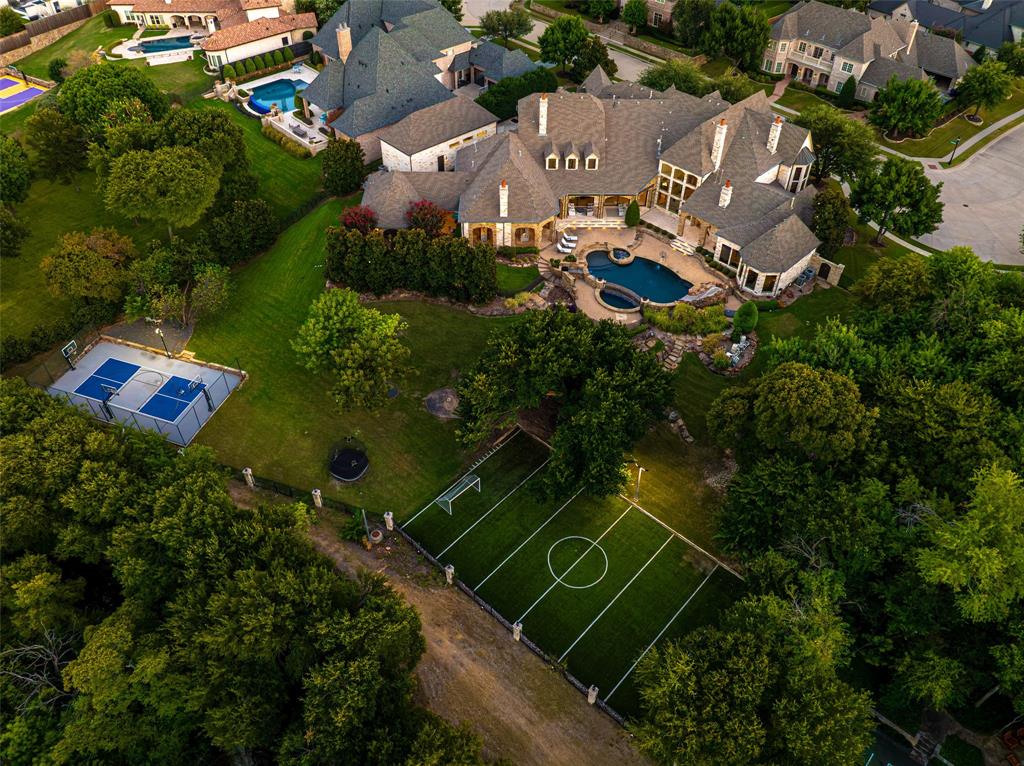 Set on approximately 1.5 acres in Frisco’s coveted Chapel Creek neighborhood, 8096 Vistaview Place is a distinctive estate offering an exceptional combination of scale, privacy and resort-style amenities. Custom built in 2011, the 9,969-SF main residence was extensively updated in 2020 with steel doors and modern finishes throughout much of the home.The thoughtfully designed floor plan features 5 bedrooms, each with an en-suite bath, including the primary suite and separate guest suite on the first level, with 3 additional en-suite bedrooms upstairs. Two powder baths are also located on the first floor. Four distinct living areas include a formal living room, casual living area adjoining the kitchen and breakfast room, separate entertaining room with bar, and upstairs game room. A private study, formal dining room, craft room, laundry and mudroom provide additional living and functional spaces. The kitchen features commercial-grade appliances and generous space for gathering and entertaining.The primary suite is a private retreat with separate sitting area, dual closets and private water closets, plus a dedicated fitness room located off the primary bath.Expansive living areas open to a large covered patio overlooking the pool and beautifully landscaped grounds, creating an ideal setting for both large-scale entertaining and relaxed everyday living. A separate guest casita of nearly 600 SF includes its own living room, kitchen, bedroom, full bath and covered patio.An extraordinary collection of recreational amenities includes a full gym, indoor basketball court, resort-style pool, outdoor sport court and dedicated soccer field. A porte cochere and 4-car garage complete this exceptional Chapel Creek estate.