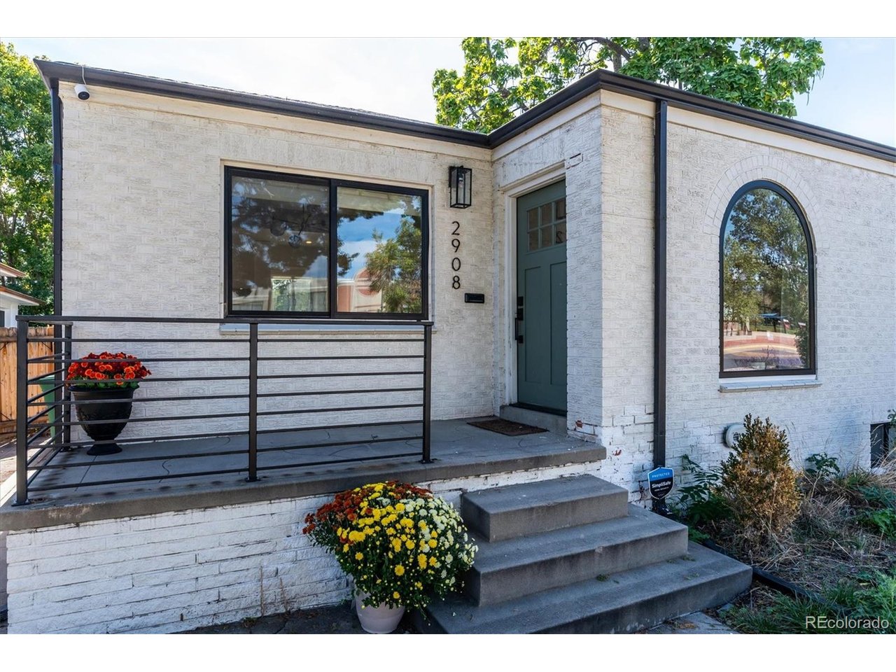 Classic Sunnyside brick with a designer soul. This fully remodeled single-family home by Goodhouse blends historic character with a modern, functional layout, and the details show throughout: custom built-ins, architectural crown molding and original hardwood floors refinished to a warm glow. A cozy front porch and oversized arched window set the tone, filling the home with natural light. The open living and dining areas flow into a well-designed kitchen with quartz counters, open shelving, a custom range hood, pantry cabinet and an oversized island with seating for three, making it an easy space for both everyday living and entertaining. Two bedrooms on the main floor offer flexibility for guests, kids or a home office. Tucked away for privacy, the primary suite is a true retreat with a walk-in closet and spa-inspired bath featuring a glass shower, green double vanity and Carrara marble floors. It's joined by an additional bedroom, spacious family room and laundry, all with 7' ceilings and no soffits. Outside, the oversized private backyard is made for entertaining, with a covered patio, a second outdoor dining area and a fire pit lounge, all set in low-maintenance landscaping. A paver walkway leads to the 1-car garage and off-street pad for 2+ cars. Set on a quiet street, you're a short stroll to some of Denver's best coffee and dining, including Bacon Social House, El Jefe, Locavore, Odie B's and The Wolf's Tailor. Remodel was fully permitted and completed by licensed contractors, including new mechanical, electrical and plumbing.