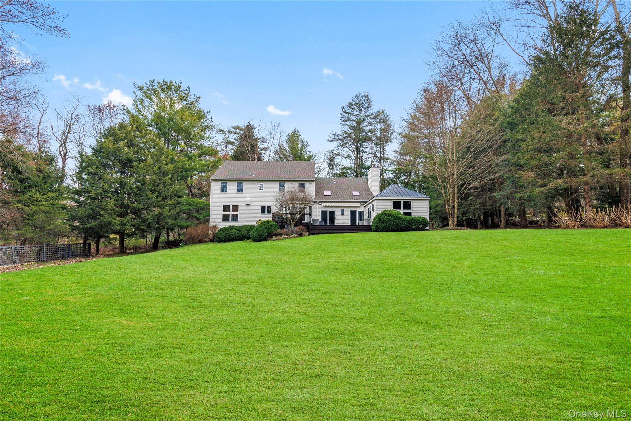 Magnificent home set on 4.6 acres of land offering privacy with panoramic views and a pristine modern interior. The first floor of this home features a  custom Poggenpohl kitchen with center island and high end appliances that flows to a casual dining and sitting area with a fireplace. The family room boasts a tray ceiling with sliding glass doors to an expansive deck overlooking the beautiful back yard.  A spectacular 2 story living room with great wall space to display art and photos, with large glass windows that offer plenty of natural light,  a formal dining room, first floor bedroom with a full bath, laundry and powder room complete the main level. The second floor has  has a spacious primary bedroom and  bath with 2 sinks, soaking tub, shower and make up area. Another bedroom, hall bathroom, and 4th bedroom/office complete the second floor.  The lower level is great space with plenty of room for storage and can be finished. Additional amenities include, house generator, brand new roof, 2 car garage, water filtration system, flat private property with plenty of room for a pool.
