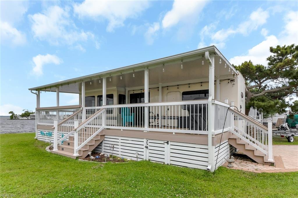 Welcome to your slice of paradise on the Back Bay! This oversized lot (.11 acres) offers ample space for outdoor living and comes complete with a private dock—perfect for fishing, kayaking, or simply enjoying the tranquil waters. Parked on the lot is a beautifully maintained 2018 Cedar Creek RV, fully equipped for comfort and styled like a cozy coastal retreat. Step out onto a custom-built deck with a large awning for shade and relaxation, ideal for entertaining or soaking in the peaceful surroundings. Enjoy stunning water and sunset views that light up the sky every evening.  Lot price $280,000 and the deck, awning and trailer & all contents convey for $155,000 The association amenities are impressive featuring a boat launch, 2 pools, clubhouse, recreation room, basketball court, volleyball court, tennis courts, laundry facilities and playground. The monthly condo fee is $333. which includes water, sewer, trash, basic cable access and ground maintenance.