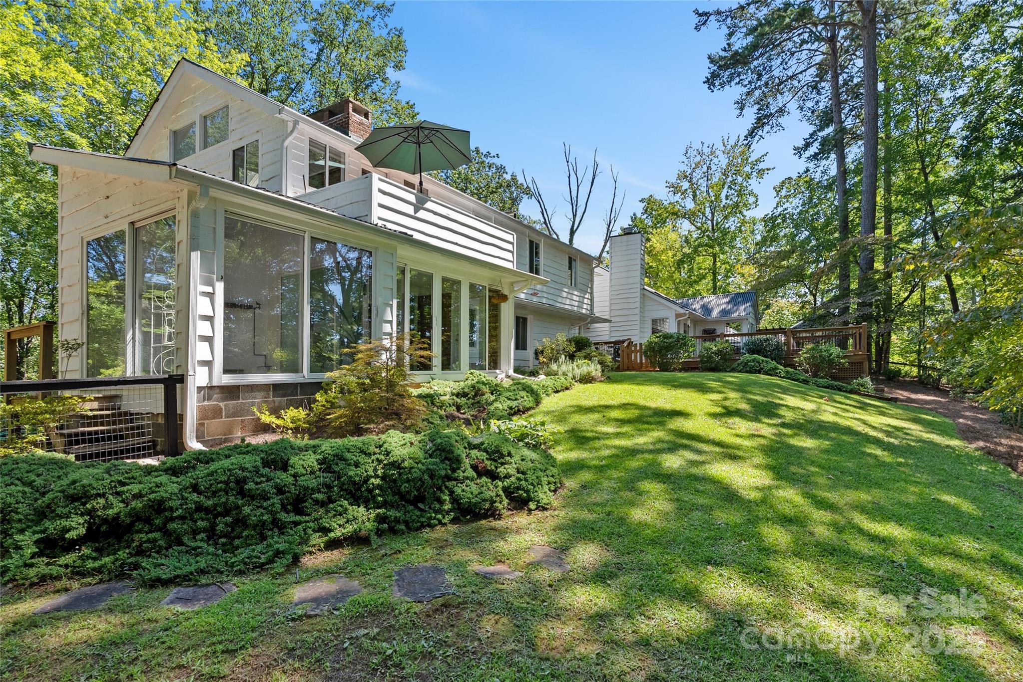 CLASSIC TRYON HOMESTEAD with year round mountain views! Extremely private location but minutes to Downtown Tryon. This fabulous home has been beautifully restored - chef's dream kitchen, gorgeous hardwood floors, two primary suites, library, sunroom and a large addition with a cathedral ceiling and its own separate entrance that would make a great home office or second living quarters. You will love the outdoor living spaces! Newly landscaped grounds with flowering plants, new expansive deck, back yard fully fenced. Properties of this quality rarely come on the market, this is a must see!