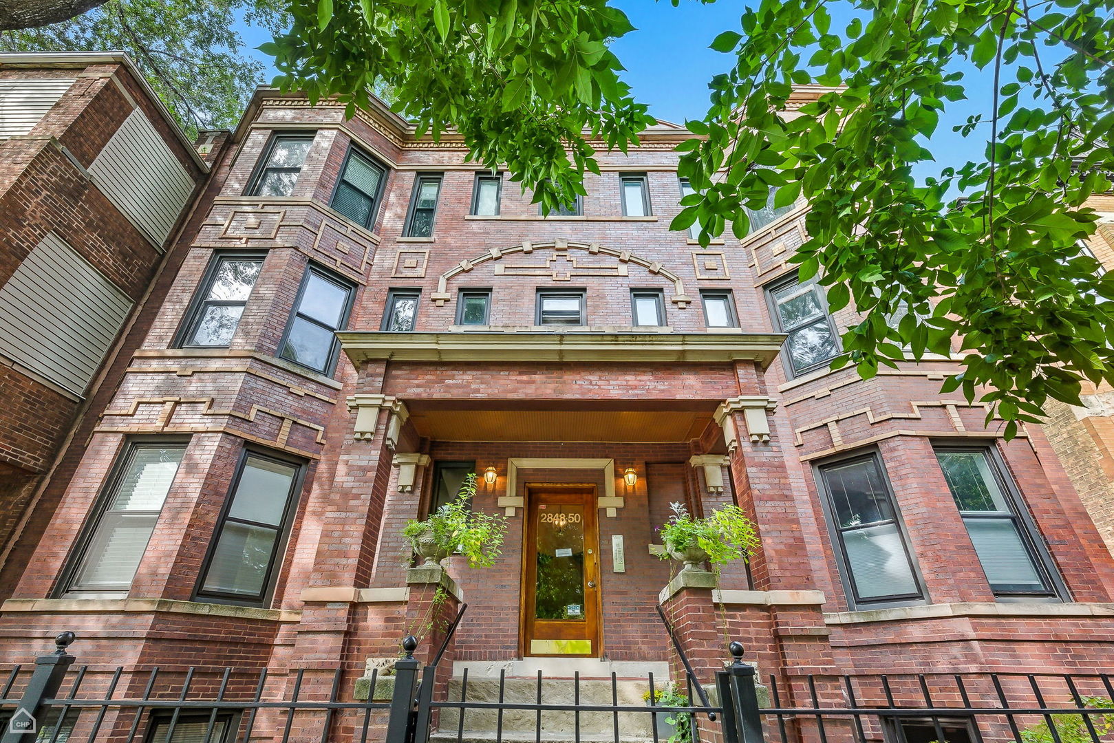 Bright and spacious 2 bed/2 bath garden-level condo in a charming brick 8-unit building on a quiet, tree-lined street. This home features an updated kitchen with new cabinets, stainless steel appliances, a brand-new island topped with butcher block countertops, a built-in dry bar with wine refrigerator, and generous storage space, all with room for a full dining table. The primary bath offers natural stone finishes and a whirlpool tub, while the second full bath has been tastefully updated with a walk-in shower and a modern vanity. Freshly painted and move-in ready, the condo boasts newly refinished hardwood floors, high ceilings, central air, and gas-forced heat. A versatile mudroom provides additional storage and doubles as an ideal home office or creative workspace. Step outside to your private outdoor deck, perfect for entertaining, relaxing, or gardening. Secure gated parking is included, along with the convenience of in-unit laundry. Just 2.5 blocks from Logan Boulevard and four blocks from the Blue Line, with quick access to I-90/94, this home is within easy walking distance of shops, restaurants, farmers markets, and green spaces that make Avondale and Logan Square such sought-after neighborhoods.