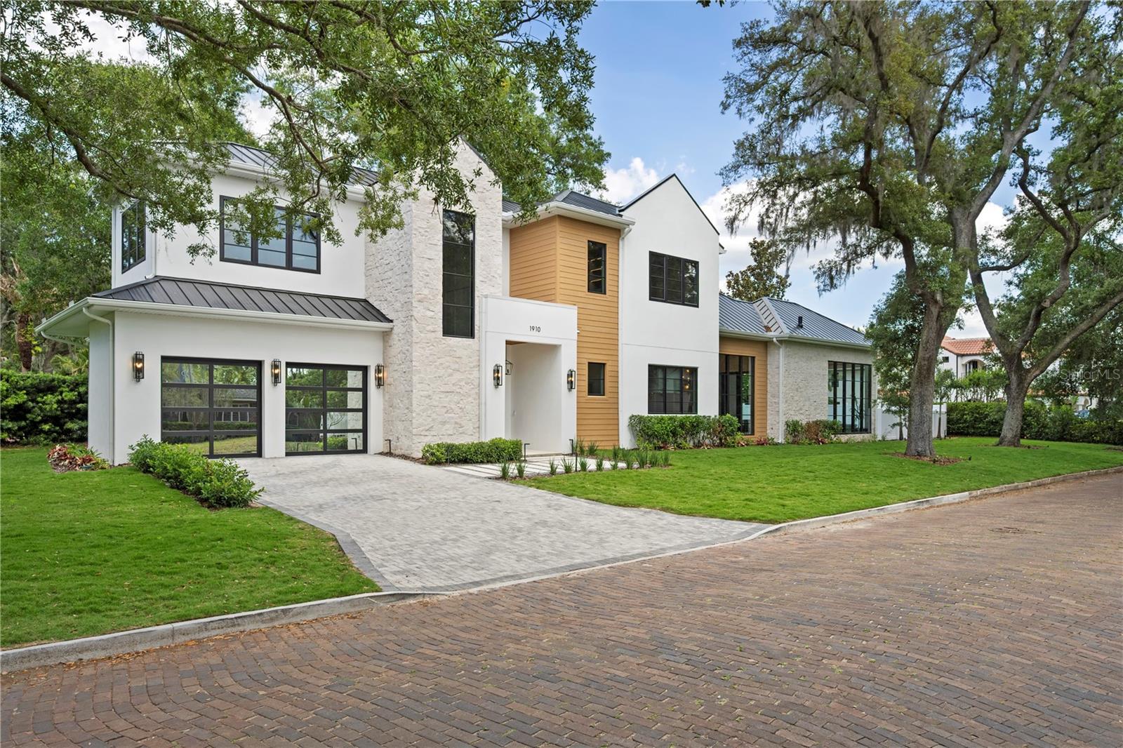 2026 PARADE OF HOMES ENTRY! - Positioned on an expansive corner lot in the heart of Winter Park, this extraordinary new masterpiece is a true architectural statement, delivering a level of craftsmanship and detail that is simply unforgettable. Framed by a massive front yard and a canopy of mature trees, the bold modern façade creates an immediate sense of arrival and sets the tone for what lies within. A grand set of double doors opens to a breathtaking two-story entry, where a dramatic marble mosaic feature establishes the home’s elevated design from the moment you step inside. The main living space is nothing short of stunning, anchored by a sleek electric fireplace and custom built-ins with integrated LED underlighting. At the heart of the home, the chef’s kitchen is a true showpiece, outfitted with Dekton Cosentino countertops, a paneled refrigerator, a full suite of Thermador appliances, and a hidden walk-in pantry. The kitchen flows effortlessly into the dining room which is bathed in natural light from an oversized statement window, making it perfect for hosting at any scale. Designed with versatility and luxury in mind, the home features two primary suites, one on each level. The downstairs primary offers soaring 12-foot ceilings and a serene, spa-like bath wrapped in marble mosaic tile. Upstairs, the main primary suite is a true showstopper, defined by its scale and attention to detail. Dual custom closet systems include an expansive hers closet complete with a dedicated makeup vanity, while the bathroom delivers a resort-caliber experience with stunning marble floors, a freestanding soaking tub, and dual vanities. The upper level continues to impress with a spacious loft designed for both relaxation and entertaining, complete with a custom entertainment center, wet bar, wine fridge, and a full bath. Each additional bedroom is ensuite, offering privacy and comfort for family and guests alike. Outdoor living rivals that of a private resort. A massive covered lanai features a fully equipped summer kitchen with tile backsplash, overlooking an expansive lounging area framed by a wall of glass. The heated pool and spa create the ultimate setting for year-round enjoyment, while the oversized front yard (an incredibly rare find in Winter Park), adds an unmatched sense of space and setting rarely found in this market. Additional features further elevate the home, including a sleek metal roof, striking hex LED lighting in the garage, and curated designer lighting fixtures throughout. Perfectly positioned just moments from Lake Chelton and Virginia Heights Park, with easy access to the boutiques and dining of Park Avenue and the charm of Hannibal Square, this residence offers a lifestyle that is as elevated as the home itself.