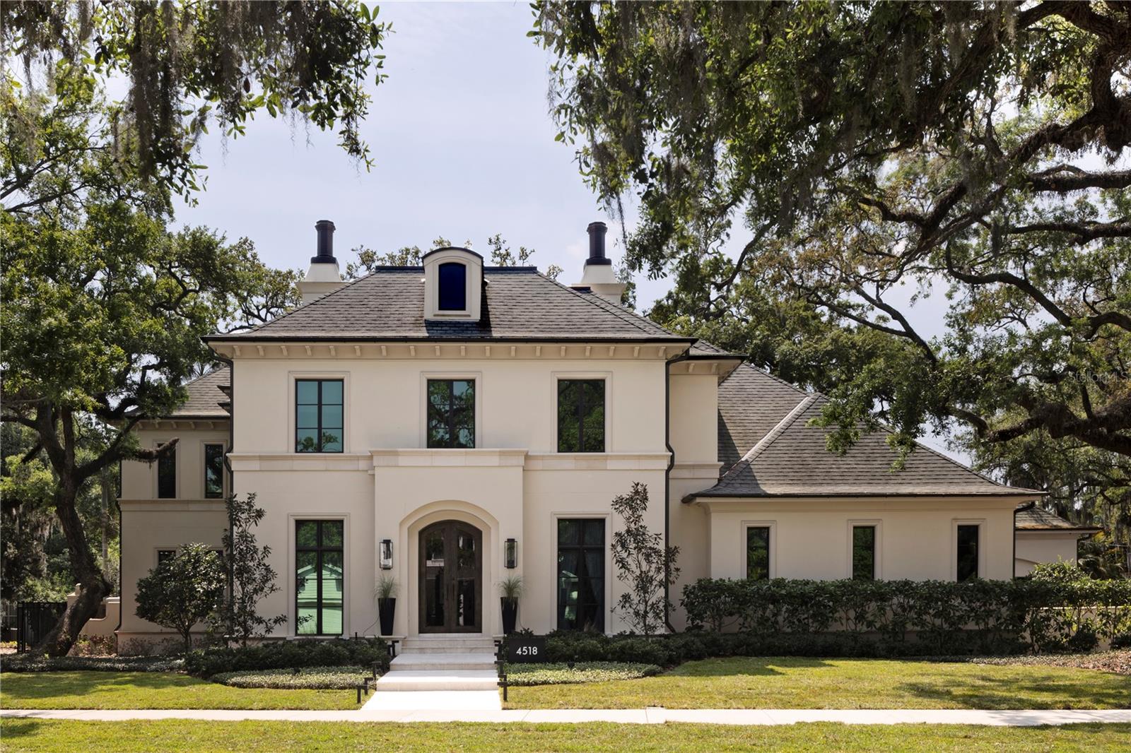 An exceptional Windstar custom-built estate in South Tampa’s coveted Beach Park neighborhood, where refined design meets resort-style living. Completed in 2018 and enhanced in 2022, this impressive residence spans over 6,200 square feet and is thoughtfully designed for elevated everyday living and unforgettable entertaining. At the heart of the home is a gourmet kitchen—a true culinary showpiece—featuring dual oversized islands, ideal for hosting and gathering. Outfitted with Sub-Zero refrigeration, a Wolf gas range, two dishwashers, two sinks, an expansive walk-in pantry, and ample storage space. This kitchen seamlessly blends function and performance, making it a standout for chefs and entertainers alike. The home offers five bedrooms, five full bathrooms, and two half bathrooms, including a luxurious primary suite retreat complete with a cozy gas fireplace, custom closets, and separate his-and-her bathrooms designed for comfort and privacy. Additional interior amenities include an elevator, a spacious laundry room with dual washers and dryers with dedicated crafting space, and abundant storage throughout. Outdoor living is nothing short of extraordinary. Set on an oversized 140 x 144 lot (approximately 0.46 acres), the backyard has been designed as a private resort, featuring a freshly resurfaced pickleball court, putting green, gas fire pit, and a resort-style swimming pool with a slide, all surrounded by generous green space for recreation and relaxation. The first-floor living room opens seamlessly to an expansive covered lanai with phantom electric screens and a fully equipped summer kitchen, creating the ultimate indoor-outdoor entertaining experience. Car enthusiasts will appreciate the two two-car garages with three lifts, offering space for up to seven vehicles. A third-floor bonus room with a full bath and closet provides flexible use as a fifth bedroom, guest or nanny suite, fitness studio, or playroom. The first floor also includes a large bonus/playroom, home office, and family room—each designed for comfort and versatility. Completed with a Generac Home Generator, this exceptional Beach Park estate delivers a rare combination of luxury, lifestyle, and functionality in one of South Tampa’s most desirable neighborhoods.