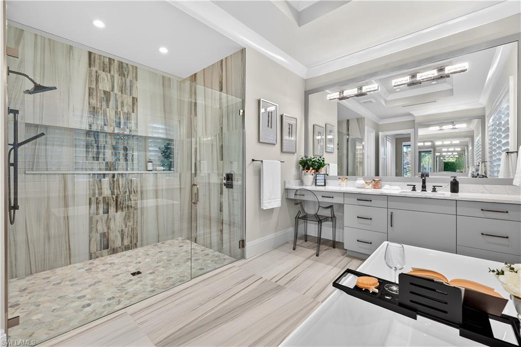 Bathroom with a shower stall, vanity, and ornamental molding
