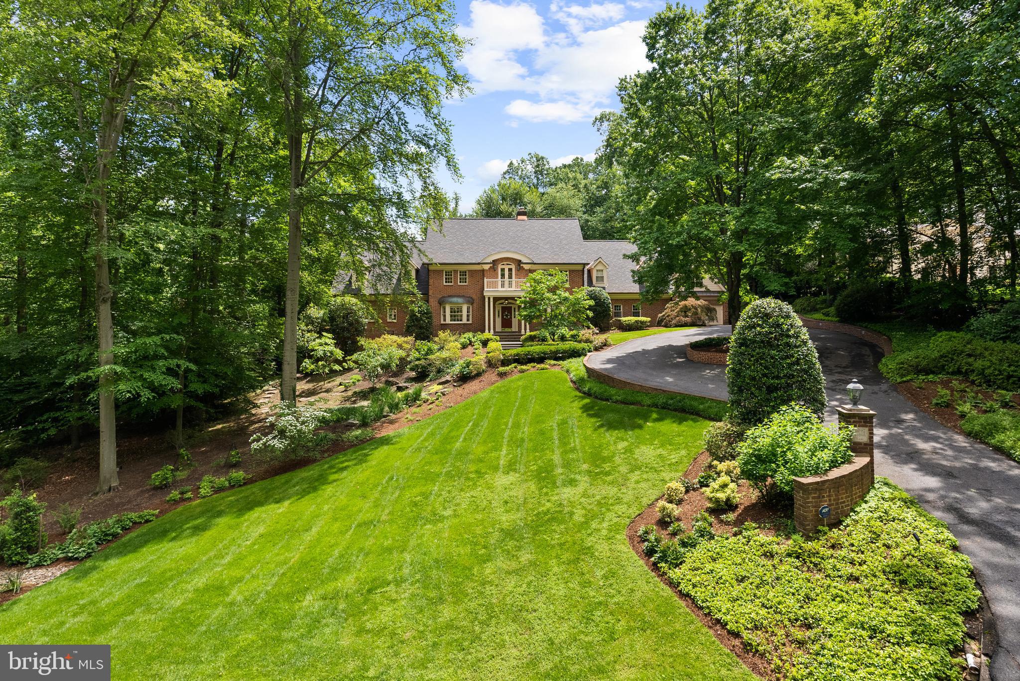 Set on a serene 1.25-acre hilltop lot in the prestigious Langley Forest neighborhood, this exquisite 8,400 SF custom-built residence offers timeless design, exceptional privacy, and sweeping treetop vistas. Designed by renowned architect Robert Holland and crafted by builder Robert Clements in 1984, the home was further expanded by BOWA in 2001 and blends classic elegance with modern updates.The main level boasts soaring 9'6" ceilings and a seamless flow between formal and informal living spaces. The open-concept kitchen and family room are perfect for entertaining, with direct access to the expansive rear deck, walkout patio, and a stunning swimming pool with gazebo—your private outdoor retreat! The mudroom features a full bath with easy access to the pool as well as a wet bar and second laundry room.Upstairs, the home features four spacious bedrooms, including a luxurious primary suite with a fully renovated spa-like bath, complete with dual vanities and a walk-in shower, as well as two dressing rooms. Two of the secondary bedrooms offer unique lofted spaces, ideal for play, study, or creative use.The lower level is designed for relaxation and recreation, featuring a large recreation room, exercise room, and full bath. A separate apartment suite above the 2-car garage provides flexible space for guests or a home office.Additional highlights include a new roof, complete exterior repainting in 2024, and beautifully landscaped grounds. Zoned for Churchill ES, Cooper MS, and Langley HS.