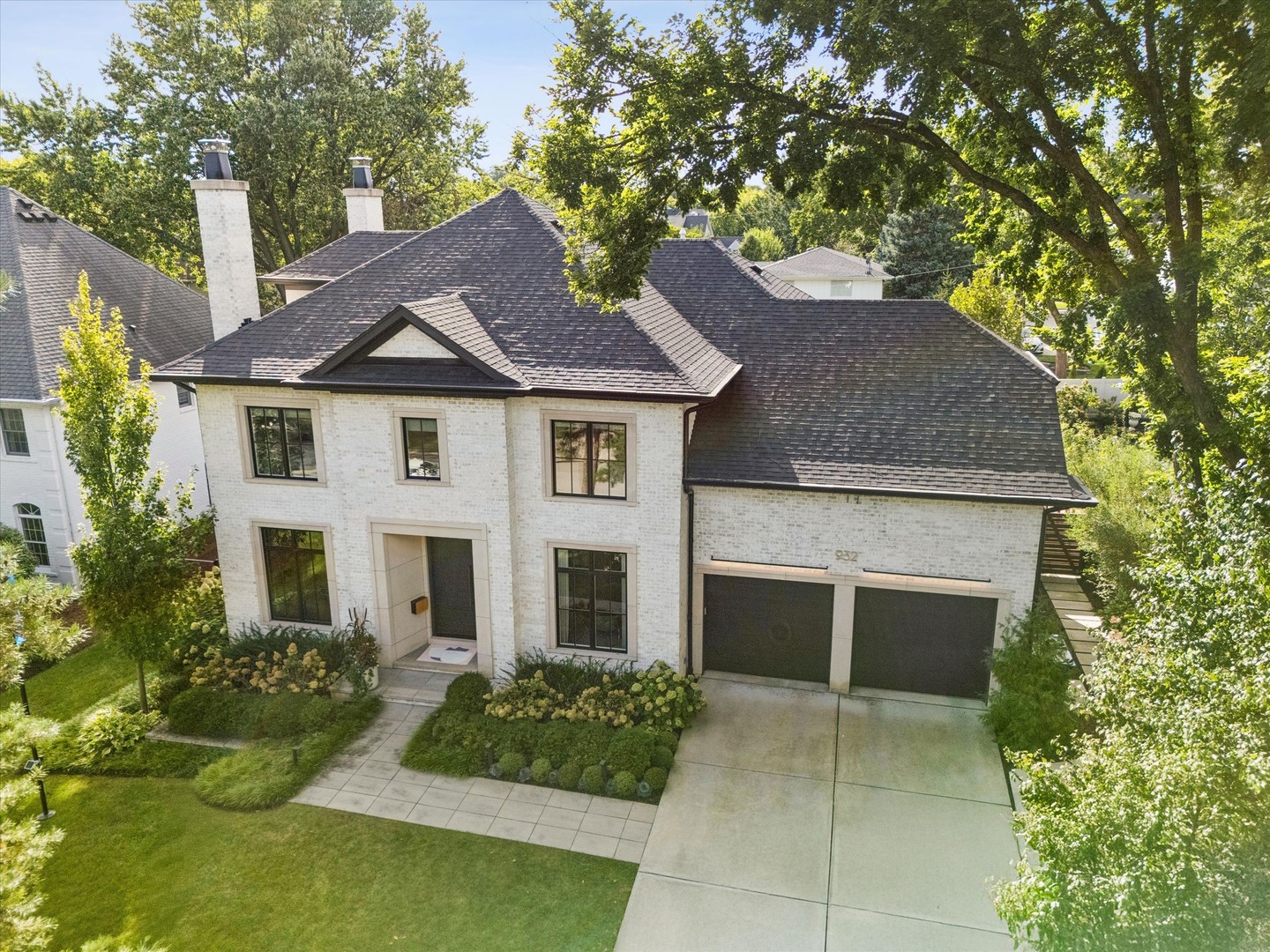 A showstopping blend of sophisticated design and modern luxury, 932 Allmen Avenue is an exceptional 6-bedroom, 5-bathroom home tucked away on a quiet cul-de-sac in one of Hinsdale's most sought-after neighborhoods. Located within the highly desirable Madison Elementary School neighborhood and just a short walk from Hinsdale Central High School, this stunning home spans four beautifully finished levels, with elevated touches and thoughtful details throughout, creating a space that feels both sophisticated and effortlessly livable.  From the moment you open the custom wood door, it's clear this is not a cookie-cutter home. A bold lounge with a marble gas fireplace, wallpapered ceiling, and walnut-paneled walls greets you as you walk in. The inviting dining room with large windows and custom treatments transitions seamlessly into the luxurious kitchen.  The kitchen is truly the heart of the home, featuring sleek custom in-lay cabinets, black granite countertops, warm brass hardware, and a statement pendant. It all sets the stage above an oversized island with ample seating.  An induction stovetop, double wall oven and Sub-Zero fridge and freezer is a chef's dream. Don't miss the backlit quartzite counter, the secret pantry filled with custom shelves, and the coffee station with its own personal waterline.  The family room is spacious with a marble gas fireplace and plenty of room for entertaining. The breakfast nook off this space feels separate yet included for casual mornings or hosting friends. Three large windows with custom window treatments and automatic shades show off the natural light year-round. Walk outside to the backyard oasis with a covered patio featuring three radiant heaters built into the ceiling, an exterior TV cabinet, and powered screens for shade and privacy.  Climb the custom stairs guided by the lit handrail to the 2nd floor filled with 5 spacious bedrooms. The primary suite offers a serene retreat with a stunning custom walnut feature wall, integrated nightstands, and warm architectural lighting. The primary bathroom has radiant heated floors, a steam shower, and a TV in the mirror. The adjoining custom walk-in closet is a dream, with beautifully organized built-ins, extensive shoe storage, drawers, and dedicated hanging space.  Throughout the bedrooms, bold wallpapers and thoughtful design details bring personality and charm while maintaining the home's sophisticated aesthetic. The second floor laundry room features double washers and double dryers with plenty of custom storage so washing clothes never feels like a chore. Head up to the third floor to a brightly lit space perfect for an office, art room or a TV lounge.  The finished lower level kicks entertainment up a notch with a spacious recreation area, a full bathroom, another bedroom, and radiant floor heating throughout. The expansive rec room is ready for fun with a wall of custom cabinets and built-in mini fridges for drinks.  Walk a few steps down to the golf simulator to play one of 100 courses or use the big screen for a movie marathon.  Built by Homecrafters in 2019, 932 Allmen is an easy walk to the shops and restaurants in downtown Hinsdale, the Metra train, many parks and nearby schools, including Hinsdale Central High School.  Sophisticated without being formal. Trendy without sacrificing timeless appeal. And luxurious without ever feeling untouchable.  This is a truly special Hinsdale home designed for the way buyers want to live today.