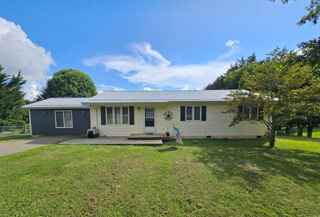 Welcome to this spacious one-level, 3-bedroom, 2-bath ranch-style home in beautiful Carroll County. Featuring hardwood and vinyl plank flooring throughout, this well-maintained home offers an inviting open living area complete with a cozy gas log fireplace. The kitchen boasts ample cabinet and countertop space, fresh paint, and stainless steel appliances. You'll also find a large den for added living or recreation space. The home features low-maintenance vinyl siding, a durable metal roof, a heat pump for year-round comfort, and a whole-house generator for peace of mind. Outside, a 30x40 garage with 12-foot ceilings provides excellent storage or workshop potential. Ideally located just minutes from the Blue Ridge Parkway and the Music Center, this property offers both convenience and the charm of mountain living. Call Today!