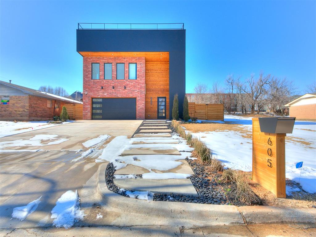 Welcome to a home where refined design meets city living in the heart of Oklahoma City. The exterior blends red brick, warm wood, and dark accents for a striking presence, and a custom walkway bordered by black river rock and curated landscaping leads to the front door. Inside, the entry offers built-in shelving and a bench with gold hardware, followed by a half bath wrapped in custom leopard wallpaper that sets the home’s bold tone. The open layout highlights clean lines and modern flow. The kitchen includes a marble waterfall island, pendant lighting, and custom acrylic cabinetry with integrated appliances. The living area centers around a streamlined fireplace framed by slatted wood and built-ins, plus a dedicated wine wall. Bathrooms throughout feature gold fixtures, marble showers, and floating vanities. The primary suite includes a walk-in closet connected to its spa-inspired bathroom with a freestanding tub inside an oversized walk-in shower with dual shower heads, a rainfall fixture, and a built-in wall shelf. Designer lighting, large mirrors, and a full-length mirror add a boutique feel. Upstairs, an open office or flex space sits beside the primary bedroom, partially enclosed with wraparound glass and a custom railing overlooking the staircase. A rooftop deck crowns the home with panoramic views, built-in seating, and welded railings, with the OKC skyline—including the Devon Tower—within reach. The backyard includes a concrete patio for dining, lounging, or a firepit. A block retaining wall with integrated steps leads to a deep grass yard enclosed by a privacy fence for a secluded outdoor retreat. Minutes from downtown, the home offers quick access to restaurants, parks, and cultural destinations. Leasing available for $5,000/month (12-month minimum) or rent-to-own with 20% down and approved application. Ask about receiving 1% of your loan amount in lender credits. Schedule your showing today with the listing agent to learn more.