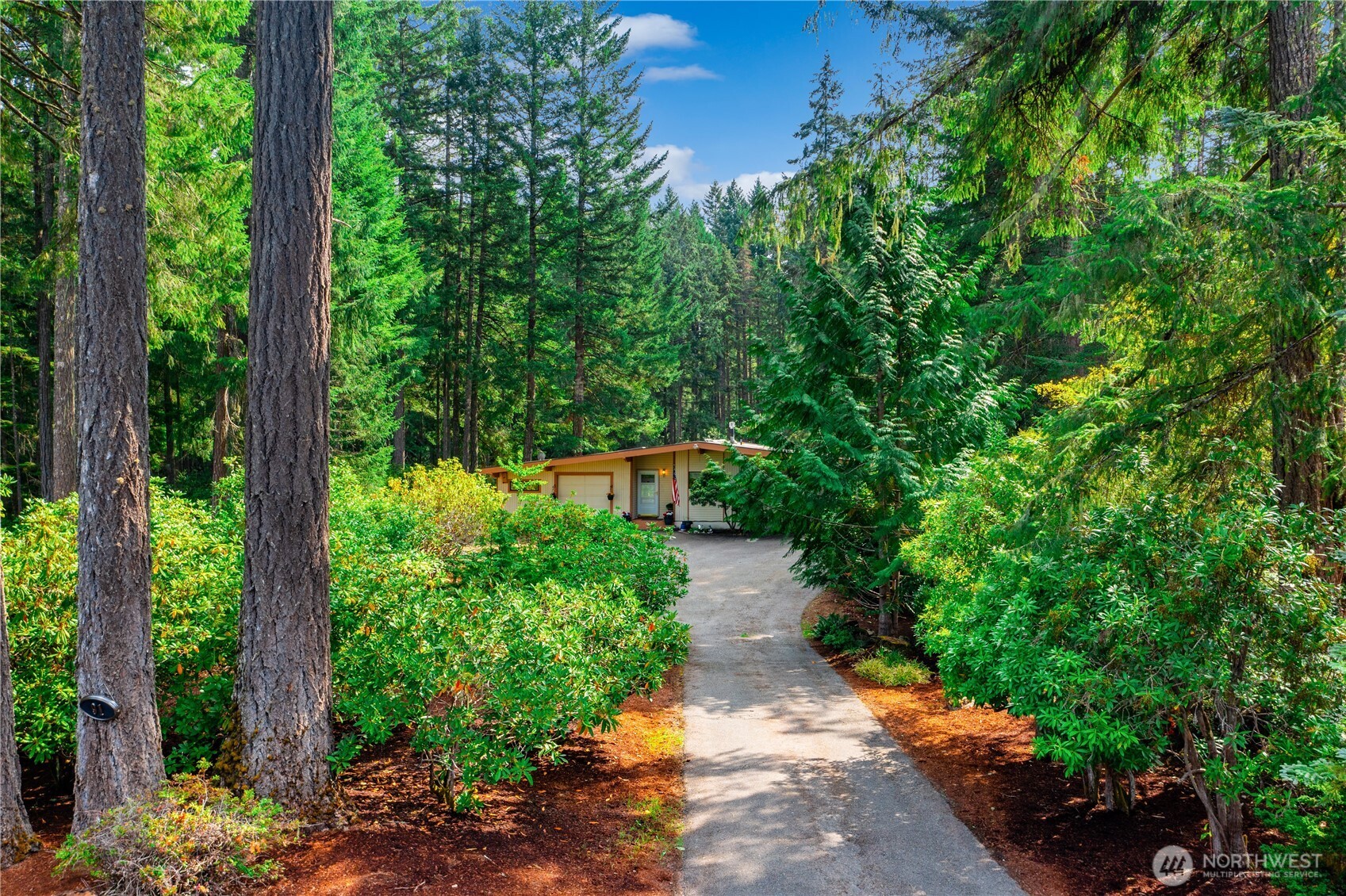 The Illusion of Seclusion! Located in the coveted Alderbrook Golf Resort, this one-story retreat offers HOA benefits including unlimited golf, clubhouse, tennis, pickleball, & community events. Set back on a private 1/3-acre lot with a long driveway, the home is surrounded by mature rhododendrons, irises, daylilies, & no grass to mow! Enjoy views of the #8 Signature Fairway from a covered deck 30 feet above the course. Open floorplan w/great room, large living room, & kitchen w/pantry & under-cabinet lighting. 2 beds plus bonus/office, 1.75 baths, generous primary suite. Features include propane stove, 2021 electrical panel, golf cart garage w/storage, outdoor BBQ area, & all appliances included. Resort living at its best.