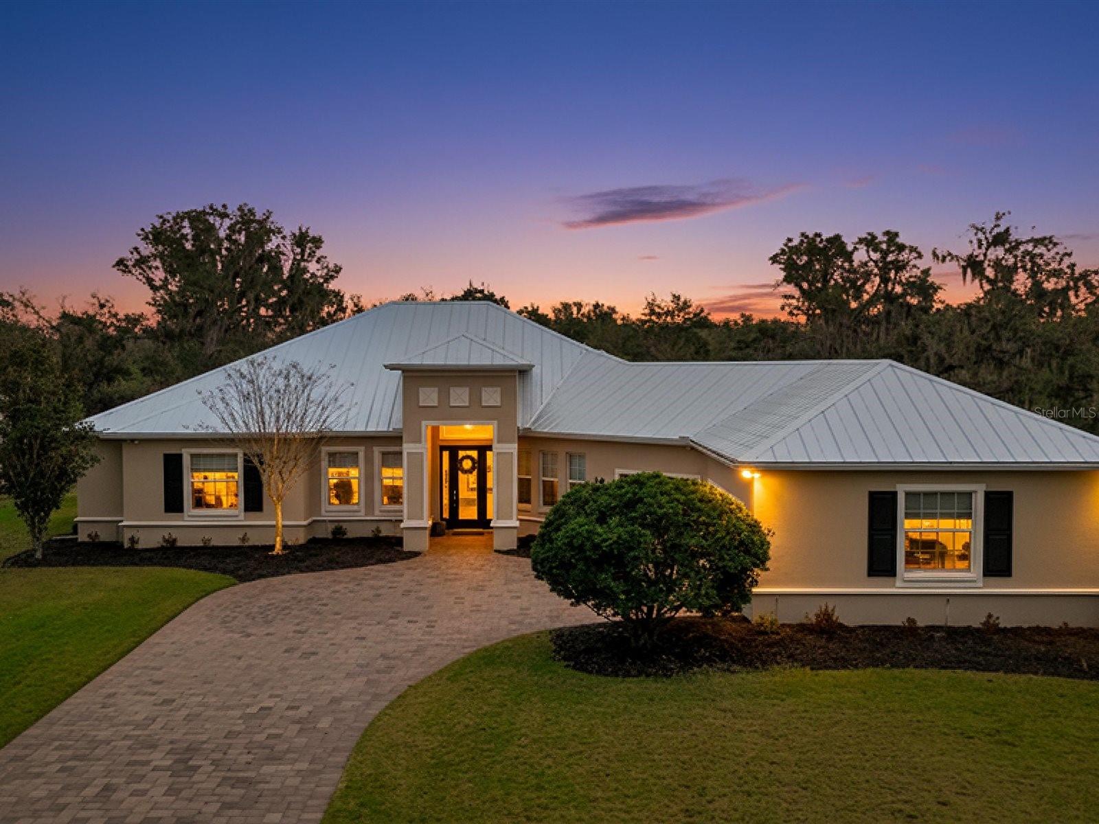 This stunning custom Medallion Home—crafted in the highly sought after Caicos model—combines luxury, comfort, and thoughtful design in the desirable Twin Rivers community. Featuring 3 spacious bedrooms, each with its own private en suite bath, plus an additional half bath for guests, the home offers exceptional privacy and convenience for everyday living. An expansive open concept layout highlights rich real wood flooring, soaring 8 foot interior doors, and abundant natural light that enhances the home’s warm, inviting atmosphere. The gourmet kitchen stands out with granite countertops, real wood cabinetry, and a layout ideal for both cooking and entertaining. A dedicated office provides the perfect space for work or study. Major upgrades add long term value and peace of mind, including a brand new metal roof installed in 2025 and a new AC system added in 2022. Outdoors, the impressive living space centers around a sparkling pool equipped with advanced safety features such as a wave monitor alert system and a secure pool fence. Driveway sensors add an additional layer of convenience and security. Blending elegant finishes, modern updates, and family friendly safety features, this exceptional property delivers an elevated lifestyle in one of the area’s most welcoming neighborhoods.