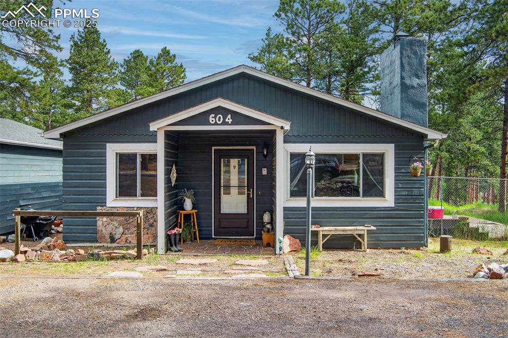 Darling cabin in the woods! This delightful home is situated amidst the trees on a large corner lot. It includes a shed, stable and 2 car detached garage. You enter the home into a very large living room with beautiful hardwood floors and a wood burning fireplace. The kitchen has everything you need including a refrigerator, dishwasher and gas stove/oven. It is separated from the dining area with a breakfast bar. The dining area has plenty of room for a table and hutch. The laundry area is off the back of the home and includes a washer and dryer. There are 2 bedrooms and a nice bathroom with glass block. The lot on this property already has a 2nd water tap, for further improvement if wanted. The home is very conveniently located and within walking distance to town, parks, schools, shopping. A quiet and peaceful place to enjoy mountain living.