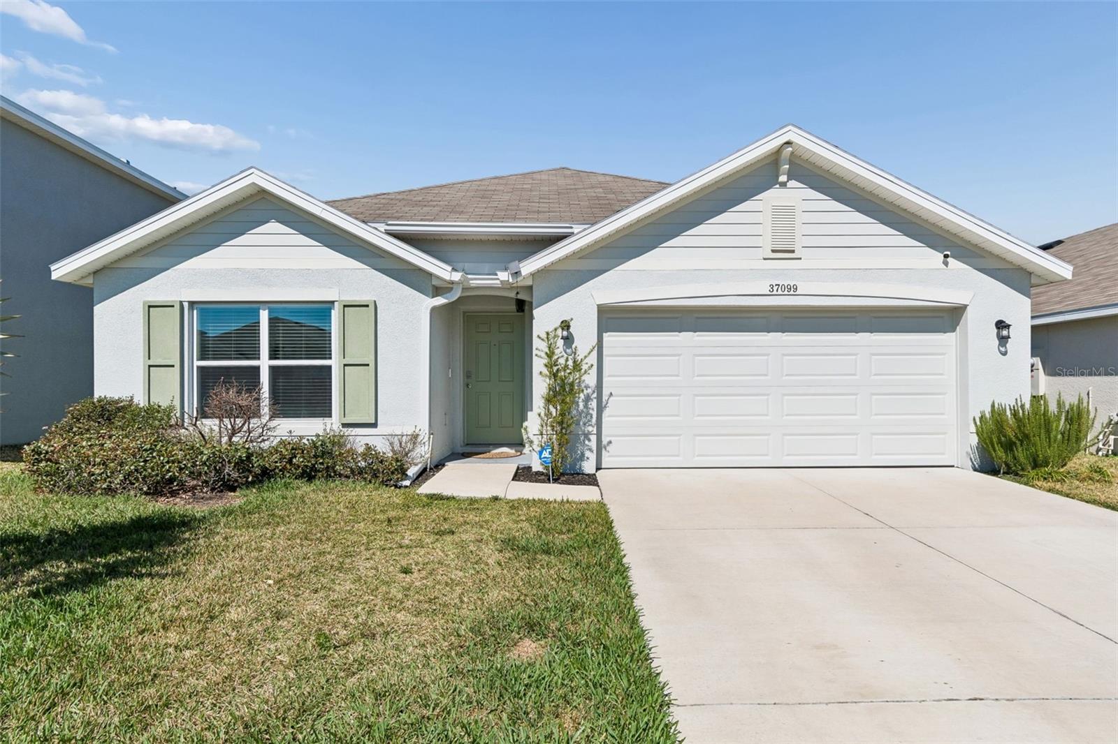 Built in 2023 by DR Horton, this ALL-CONCRETE BLOCK 4-bedroom, 2-bath home with a 2-car garage is located in the desirable Zephyr Ridge community and offers 1,828 SQFT of thoughtfully designed living space. The popular Cali floor plan features an OPEN LAYOUT with extended tile in the main living and dining areas, a spacious great room, and a well-appointed kitchen with GRANITE COUNTERTOPS, stainless steel appliances, ample cabinet space, and a large pantry. The primary suite has been upgraded with a beautiful ALL-GLASS SHOWER ENCLOSURE, creating a more elevated and modern feel, along with generous closet space and a private bath. Three additional bedrooms provide flexibility for guests, a home office, or growing households. Sliding glass doors bring in natural light and lead to the covered porch complete with a TV OUTLET and ceiling fan, overlooking the FULLY FENCED BACKYARD  that offers privacy and space to relax or entertain. The seller enhanced the curb appeal with a beautiful Bismarck palm in the front yard, adding an elegant and distinctive Florida touch. This home includes DR Horton’s “Home is Connected” Smart Home system for added convenience. Zephyr Ridge offers a community pool and patio area for relaxing and entertaining, LOW MONTHLY HOA, and is ideally located just off SR-54 with easy access to Tampa, Lakeland, and Orlando. You’re less than 10 minutes to Publix, restaurants, and golf courses, and approximately 20 minutes to The Shoppes at Wiregrass and Tampa Premium Outlets, with Downtown Tampa and Tampa International Airport about 45 minutes away. Almost new, move-in ready construction without the wait!