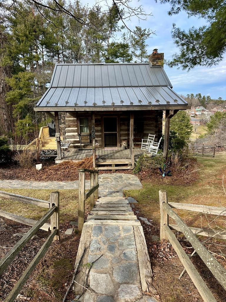 This unique gem of a property is the perfect retreat, all while being conveniently located in Galax. The original cabin has been disassembled, transported, and reconstructed with modern amenities. The current owner has enjoyed it as a full-time residence, but you can also use it as your mountain getaway.  With an extended back deck, a hot tub, and a fenced-in yard, this property offers an ideal setting to relax and unwind in the evenings. As you walk through the heavy, handcrafted door, you'll feel a sense of nostalgia. You can relax in front of the stone fireplace and ascend the stairs to the quiet loft. This cabin truly embodies the essence of the Appalachian Mountains!