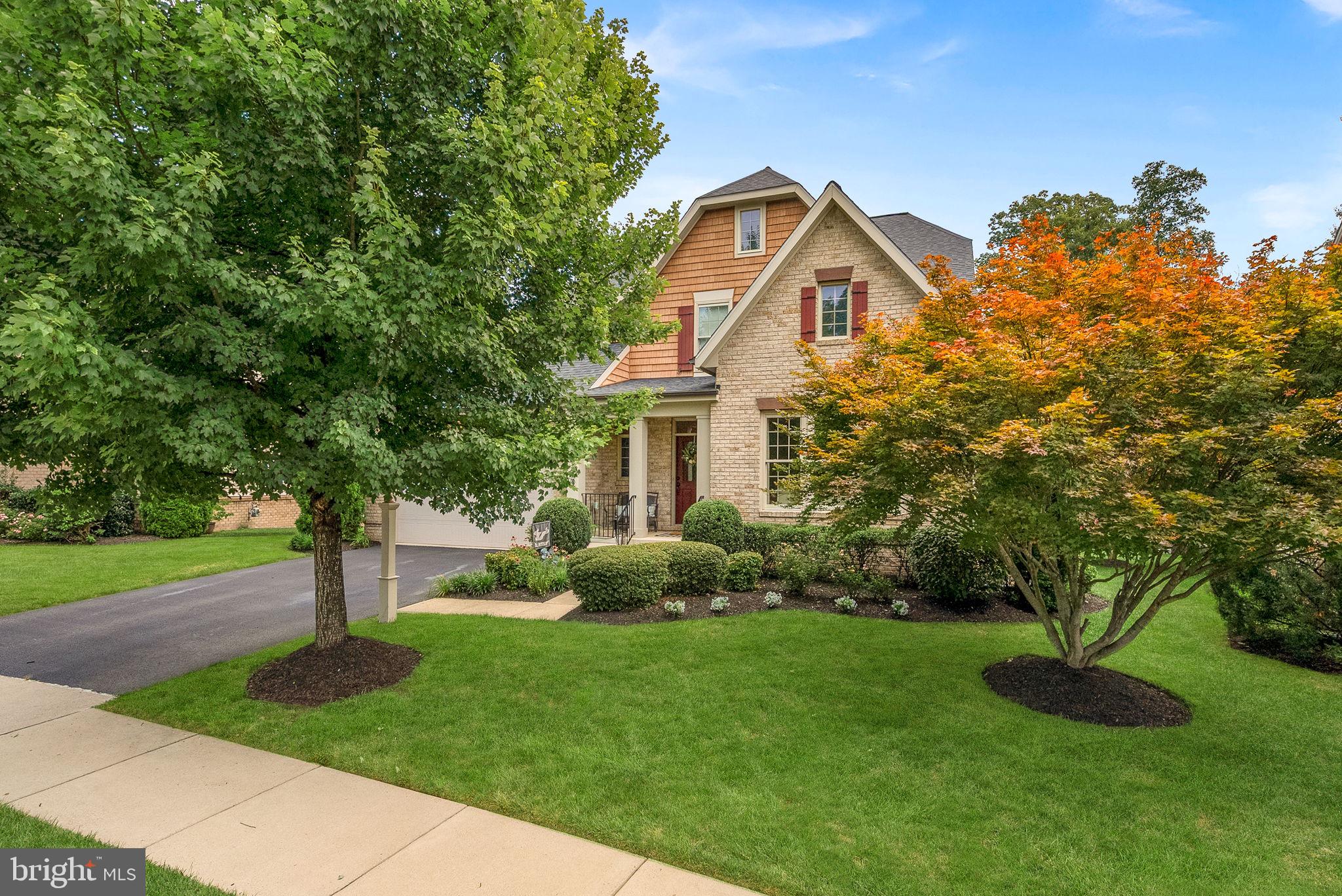STAY TUNED FOR ADDITIONAL PROFESSIONAL PHOTOS! Timeless English Manor elegance meets modern comfort in this exceptional home designed for today's lifestyle. Backing to mature trees and community open space, this beautifully appointed Miller & Smith Taymouth floor plan offers the perfect blend of luxury, privacy, and flexible living with an ideal layout for multi-generational households. Rich, wide-plank hardwood flooring flows throughout the main level and up the staircase, while the thoughtfully designed floor plan also offers a formal living or dining room, a convenient mudroom, and a timeless gourmet kitchen with granite countertops, cream cabinetry, a natural wood island, double wall ovens, a newer French door refrigerator, newer dishwasher, and newer built-in microwave. The expansive great room is off the kitchen with a gas fireplace as the focal point. Step out to the deck and gorgeous backyard. The luxurious main-level primary suite features a spacious sitting room or private office with closet with pocket door, an additional walk-in closet, and a spa-inspired bath featuring a soaking tub and separate shower. Upstairs, you'll find a full level of LVP flooring and an impressive second bedroom suite with a private bath and custom walk-in closet, two additional generously sized bedrooms, and a versatile loft that provides the perfect space for a second family room, home office, or study area. Should the new owner require a fourth bedrooms upstair, the loft can easily be walled off for a fourth bedroom.. The fully finished lower level is an entertainer's dream and offers incredible flexibility with luxury vinyl plank flooring throughout, an expansive recreation room featuring a gas fireplace and a full wall of custom built-in cabinetry, a dedicated media room, an additional bedroom with a custom walk-in closet, and a full bathroom. Four full-size windows provide abundant natural light and multiple areaway exit options, while two oversized storage rooms—including one with custom shelving—offer exceptional storage space. Outdoor living is equally impressive with a spacious deck overlooking the peaceful wooded backdrop and common area, creating the perfect setting for relaxing or entertaining. Additional highlights include an irrigation system, updated HVAC and furnace and numerous custom features throughout. This exceptional property offers the rare combination of timeless architecture, luxurious finishes, and a highly functional floor plan designed to accommodate every stage of life. Enjoy all Brambleton Community amenities - pools, parks, town center with shops, restaurants, gym, theater, Brambleton Library, Hanson Regional Park and Beaverdam Reservoir are a five-minute drive away. HOA fee includes upgraded Verizon FiOS internet and cable. Conveniently located to major roadways - Loudoun County Parkway, Route 28 and Dulles Greenway as well as Dulles Airport and the Ashburn Metro Station. Zoned for Madison's Trust, Watson Mountain Middle, Independence High School.