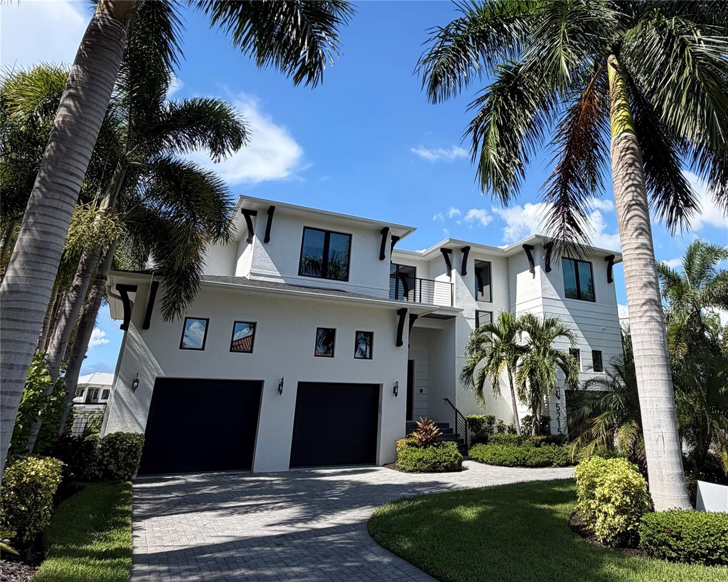 Welcome to a rare waterfront opportunity at the coveted end of West Neptune Way in Beach Park—a Steven Anthony Luxury Homes showcase offering sophisticated design, abundant storage, and resort-style outdoor living. This stunning 5-bedroom, 5.5-bathroom pool and spa home also features a dedicated office, expansive bonus/media room, and covered lanais under roof on both floors, creating exceptional indoor-outdoor living. Thoughtfully positioned to capture western-facing views, the home offers spectacular sunsets over the Tampa skyline and water. Set along one of Tampa’s most desirable waterfront stretches, the home enjoys exceptional street presence with no overhead power lines, attractive street lighting, and beautiful curb appeal. Inside, a thoughtfully designed floor plan features soaring 12-foot ceilings, generous living spaces, and elevated finishes throughout. The chef’s kitchen is equipped with Wolf appliances, Wellborn cabinetry, an oversized walk-in pantry, and separate butler’s pantry, making it ideal for everyday living and entertaining. In the family room, a dramatic floor-to-ceiling tiled wall with a natural gas fireplace and integrated LED lighting creates a striking focal point. Built-in speakers throughout the interior and outdoor living areas enhance the home’s entertaining capabilities. A private first-floor guest suite features an en-suite bath, built-ins, and separate exterior entrance—ideal for overnight guests or extended stays. A dedicated office offers extensive built-in shelving, while a powder bath and laundry rooms on both floors add convenience. Upstairs, additional en-suite bedrooms provide privacy and flexibility, while the impressive bonus/media room features a dry bar and direct access to the second-floor covered lanai. The spacious primary suite is a retreat of its own and includes a private dry bar. An elevator shaft is in place for the option of a future elevator. Storage has been exceptionally well considered throughout. The air-conditioned garage features floor-to-ceiling built-in cabinetry and space for multiple vehicles, including a LiftMaster setup. Additional conveniences include three HVAC systems installed in 2020, two tankless water heaters, a Kinetico water system with purified drinking water, full irrigation, and an owned 22kW Generac whole-house generator.Outside, the home transforms into a private waterfront retreat designed for year-round Florida living. Covered lanais on both floors provide shaded outdoor living overlooking the water, pool, and spa, with the western orientation creating an incredible backdrop as the sun sets over the Tampa skyline. Low-maintenance turf surrounds the pool and spa, complemented by full LED pool lighting, while a gas fireplace creates an inviting gathering space. The fully equipped outdoor kitchen features an Alfresco grill with smoker and side burner, along with a dry bar and extended cabinetry. Landscape lighting throughout the trees creates a beautiful setting after sunset, while pet-friendly gates and fencing add functionality. For days on the water, the custom dock is designed for boating and watersports, with dock and underwater lighting, a covered boat lift, custom steps for easy boat access, and dedicated kayak and paddleboard storage. From sunset gatherings and poolside entertaining to effortless water access, this exceptional Beach Park residence delivers an extraordinary waterfront lifestyle in one of Tampa’s most sought-after settings.