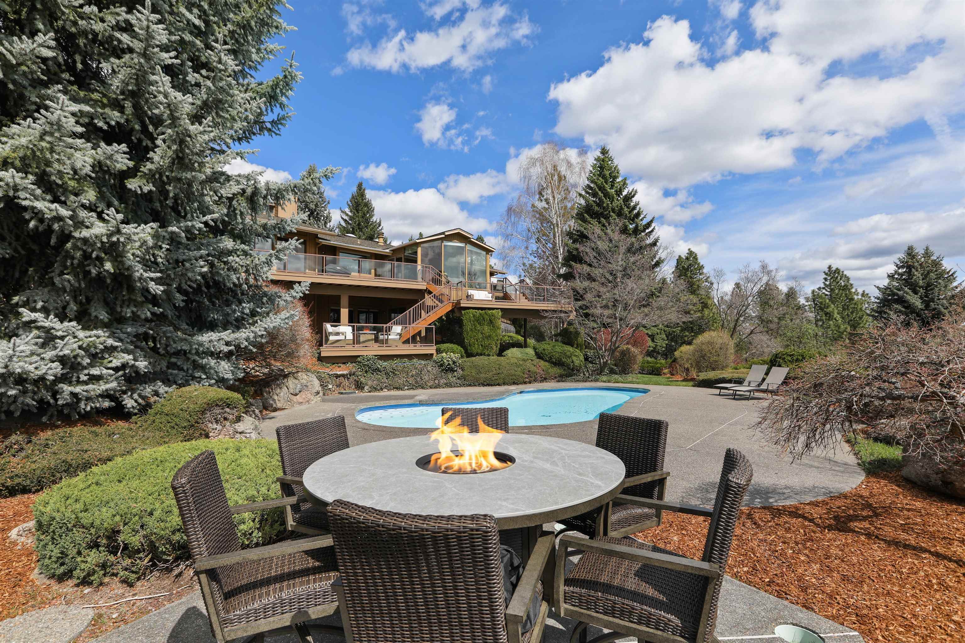 Impressive the moment you pass through the double gated entry and arrive under the grand porte cochere of this stunning 4.77-acre estate. Meticulous grounds set the stage for panoramic southerly views and exceptional outdoor living.  Expansive multi-level Trex deck—spanning over 1,300 sq ft—overlooks a resort-style setting with an inground pool, fire pit, and private tennis court. Enjoy serene mornings in the solarium, relax in the sauna or hot tub.  Fruit orchard and garden shop/greenhouse.  Car enthusiasts and hobbyists will appreciate the abundance of garage space: an 11 car attached garage plus a separate RV garage with a 14’ door and a fully equipped ADU apartment above.  Lower daylight level features spacious family and recreation rooms complete with a wet bar, sauna, and more perfect for entertaining or extended stays. Don't need all 4.77 acres?  There's potential for short plat or subdivision.  Owner wants this moved; priced $500,000 less than recent appraisal.  Short term owner financing possible.