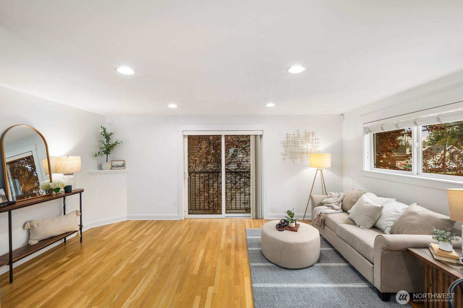 Spacious and flexible end-unit townhome in the heart of Greenwood that meets modern living. Tucked within a 3-unit community with no HOA, this home offers a perfect blend of privacy and convenience. The corner position brings in exceptional natural light through large windows while maintaining a quiet, protected feel. A wider-than-typical layout, tall ceilings, and open spaces create an airy, comfortable flow you don’t often find in Seattle townhomes. The entry level includes a flex bedroom / office and full bath with its own secure back entrance—ideal for guests, work-from-home, or rental potential. Off the entry level bed you'll find a unique oversized yard with code-equipped access that adds usable outdoor space without sacrificing privacy. The second level is dialed—featuring hardwood floors throughout the open concept living, kitchen, and dining spaces, plus a well-placed powder room off the living area. The kitchen has a gas range, ample cabinetry, bar seating, and great prep space for daily living or hosting. On the 3rd and final level, you'll find the primary suite with a double vanity en-suite and strong natural light between the mature landscaping shading the Juliet balcony. Fresh interior paint and new carpet make it truly move-in ready. Dedicated off-street parking provides everyday convenience. Steps to transit and minutes to the Lightrail. Simple commute to DT, the Eastside, and all things Seattle has to offer. Don't miss it!