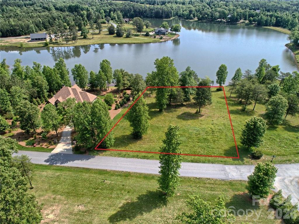 Wait!!! WATERFRONT— In DERBYSHIRE (The "Foothills" of Tryon/Columbus, North Carolina): A rare premium lakefront homesite inside one of the Foothills’ most sought-after equestrian-oriented, gated communities!!Why this lot you may ask? A True waterfront gem as a few of the great ones left, if any! In a gated, equestrian-minded community with quick highway access is exceptionally hard to replicate. Here, the topography, view corridor, and builder program come together to offer elegance + flexibility without compromise!!!Design a single-level or primary-on-main plan, add a walkout lower level for guest suites/entertaining, and step directly out to the pool and lake for seamless indoor–outdoor living!!!This setting delivers what buyers ask for but seldom find in one place—direct lake frontage for kayaking/paddleboarding, elegant country living with room to breathe, and easy, all-paved access to I-26 (Landrum exit) for quick trips to restaurants, shops, and shows. For competitors and spectators alike, the world-renowned Tryon International Equestrian Center (TIEC) is an easy drive, with schooling options, trainers, boarding, and miles of area riding opportunities at your fingertips.Build your dream—your way. The featured plan shown is one of several custom options from the builder—choose this design or tailor your own. Expect thoughtful architecture that harmonizes with the water and views, premium finishes, and modern conveniences (think Superior Walls walkout foundation, whole-home audio, and indoor–outdoor living that flows to a gunite pool terrace overlooking the lake). Bring your vision; the builder’s premium spec sheet and upgrade menu make it simple to personalize. Qualified buyers may customize prior to construction start.Lifestyle & amenities: Derbyshire’s equestrian focus and refined country aesthetic create a unique sense of place. Owners enjoy community warm-up rings, stalls, and pastures (per availability), plus quiet lanes for morning hacks, sunset lake strolls, and relaxed evenings by the water. Whether your day starts in the saddle or with coffee on the dock, this address supports a peaceful, active, and low-maintenance routine.Unbeatable regional access: From the gate, reach TIEC quickly, zip to downtown Tryon, Landrum, and Columbus for dining and services, or connect to I-26 in minutes. Traveling further? You’re approximately ~45–60 minutes (traffic dependent) to Greenville-Spartanburg (GSP) and Asheville (AVL), and roughly about an hour (+/-) to Charlotte Douglas (CLT)—a rare convenience for international and coastal travel while keeping your lake-and-horse lifestyle intact.Bring your plans & questions. The builder is available to walk the property, review preferred elevations, and discuss specifications, timelines, and allowance packages. Other home styles are available upon request. Call today to explore how this lakefront canvas can become your custom Derbyshire retreat.(*You can also view the MLS Listing which only includes the Lot.)