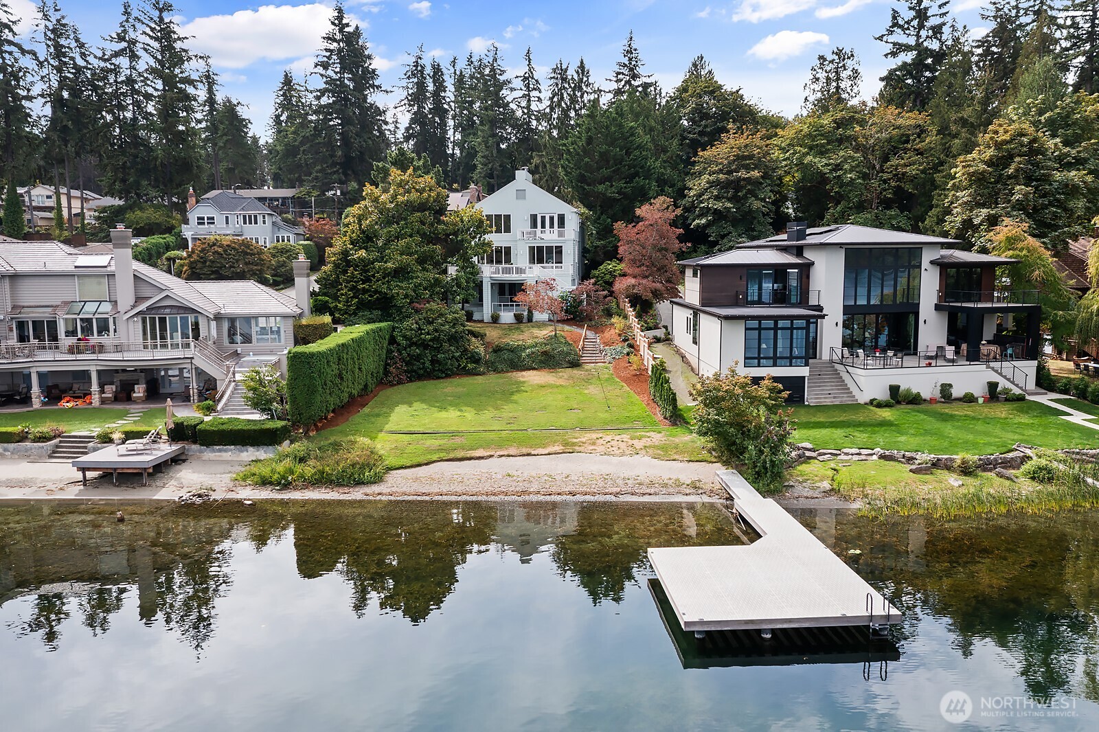 Lakefront living at its finest — 75 feet of pristine Redmond waterfront (as recently surveyed), a private dock, and a stylishly updated 4,210 sq ft home with ease of access from the street to the water. The main level has a generous open-plan layout with walls of windows bringing the light and the serene lake view into the heart of the home. Newly refinished hardwoods, updated kitchen & fresh paint throughout give the interiors a light, contemporary feel. A truly flexible floorplan with bedroom options across all three levels. The upper level offers a real sanctuary retreat with sweeping views, private deck, primary bedroom w two-way fireplace connecting to the adjoining sitting room, bedroom or office space, a super-spacious ‘double’ dressing room, and a newly refreshed Scandi-inspired spa bath featuring a new soaking tub. The lower level adds versatile living space with a large rec room, work out room and an additional bedroom & bathroom with easy walk-out access to the grounds and waterfront. Outdoor living shines here: a spacious deck for sunset dinners, large circular hot tub sweeping lawns for games & gatherings, and private beach & dock for all the waterfront fun that Lake Sammamish has to offer.