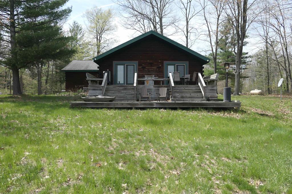 Tucked away on 15 acres including approximately 1,000 feet extending into the water on Woodruff Lake, providing a rare combination of expansive land and unique water access. This stunning 3 bedroom, 2 bath home offers the perfect blend of rustic charm and modern comfort. Enjoy true waterfront living with riparian rights and your very own island, an incredibly rare find that elevates this property to something truly special. Inside the home features an inviting open feel with high-end laminate flooring and ceramic tile throughout. Master bathroom is being renovated, offering a great opportunity for the next owner to enjoy updated finishes. A beautiful masonry fireplace with a pellet burner serves as a cozy focal point, perfect for Michigan evenings. The kitchen is beautifully updated with granite countertops and stainless steel appliances.. Step outside to a spacious 30x12 two-tier deck overlooking the lake, perfect for morning coffee, entertaining, or taking in peaceful waterfront views. Peace of mind comes with whole home Generac generator, ensuring comfort year-round. Outside you have exceptional storage and workspace options, including a 30x24 pole barn, 32x15 shed and 16x11 shed with electricity-perfect for hobbies, equipment or recreational gear. Whether your looking for a full-time residence or a private getaway, this one of a kind lakefront property delivers space, privacy and unforgettable views.