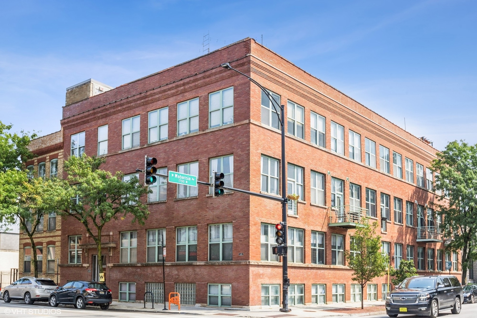 Real timber loft living on the corner of Damen and Wabansia in the heart of Bucktown. This sunny, south-facing, extra-spacious 1 bedroom (approx. 975 sq ft) in a 1926 brick warehouse conversion has the details loft buyers hunt for: exposed timber beams and ceilings, brick walls, oversized steel-framed windows and hardwood floors throughout. The open living room is anchored by a wood-burning fireplace with gas starter and opens to a private balcony set in the treetops. The kitchen offers granite counters, stainless steel appliances, a gas range and a large island with breakfast bar. Quiet bedroom overlooks the courtyard with a full wall of closets. Bath with double vanity, in-unit washer/dryer and central air. Exterior parking space and storage included. Shared roof deck with skyline views. Steps to The 606, the Damen Blue Line and the best of Bucktown dining, galleries and shopping.
