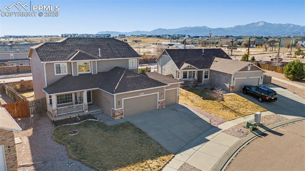 This former model home offers 4 bedrooms, 3.5 baths, and is a perfect blend of comfort, functionality, and stunning mountain views. Walk into a stunning 2 story entry with wood floors and a tile inlay with a showcase stairway leading to the upper level.  Enjoy peace of mind with a new furnace, new central A/C, and an alarm system for added security. The main level features beautiful hardwood floors, a separate formal dining room, and a dedicated office with glass French doors—ideal for working from home. The spacious kitchen showcases granite tile countertops, stainless steel appliances, tile backsplash, a center island, and abundant cabinet space. The kitchen opens to the eat-in dining area with direct access to the backyard, creating seamless indoor-outdoor living. Step outside to the fully fenced backyard with mountain views, where the pergola stays—perfect for relaxing or entertaining. The living room is warm and inviting with a gas fireplace and custom built-ins, ideal for cozy evenings at home. Upstairs, you’ll find a convenient laundry room, three bedrooms to include a private primary retreat featuring a walk-in closet and a luxurious five-piece bath. The basement is an entertainer’s paradise with a spacious family room, fourth bedroom, full bathroom, and wet bar. Additional highlights include a 3-car garage with a utility door to the backyard, separate dining room and sitting room on main level and a gas fireplace with builtins in the living room. This home is within walking distance to schools and close to parks, restaurants, shopping, the Powers Corridor, and military installations. Don’t miss this exceptional gem—schedule your showing today!