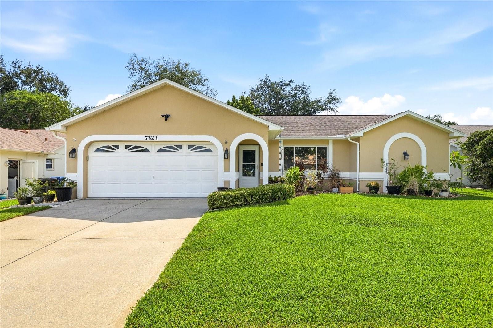 Welcome home to highly desirable Woodridge Estates! This beautifully maintained 2-bedroom, 2-bath home with a 2-car garage offers the perfect combination of comfort, functionality, and outdoor living. Situated on a private, fully fenced lot, you'll enjoy your very own above-ground pool and plenty of space to relax and entertain.From the moment you enter, soaring ceilings and an open, airy floor plan create a warm and inviting atmosphere. The heart of the home is the bright, spacious kitchen,  featuring a center island, ample cabinetry, and plenty of natural light.Both bedrooms are generously sized, and you'll appreciate the ample storage found throughout the home. The screened lanai provides additional living and entertaining space, while the newly fenced backyard creates your own private retreat.This home has been lovingly cared for and offers numerous updates, including a roof replaced in 2019, A/C replaced in 2021, hot water heater in 2015, several newer windows, new fencing, and added attic insulation for improved energy efficiency.Conveniently located just minutes from vibrant downtown New Port Richey, you'll enjoy easy access to restaurants, breweries, shopping, parks, entertainment, and the area's beautiful Gulf Coast beaches. If you're looking for a home that truly packs a lot into one exceptional property, this is one you won't want to miss!