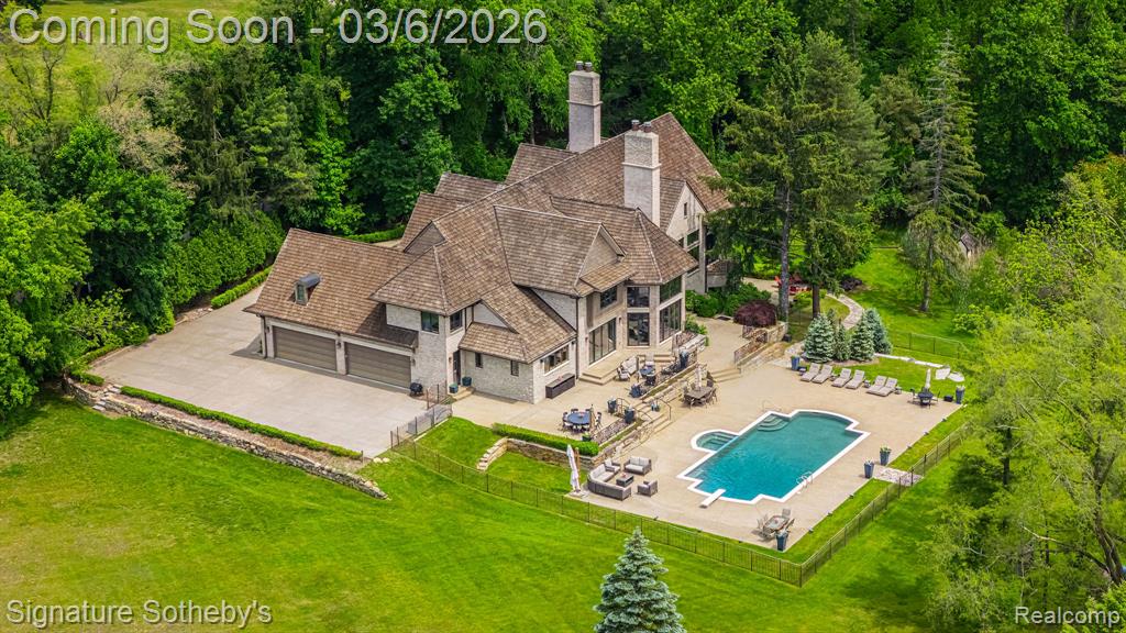 Set on 5.5 manicured acres minutes from downtown Franklin, this estate blends commanding architecture with a warm, modern sensibility. Offering over 11,000 square feet of living space, with a fully finished lower level, the home features 6 ensuite bedrooms and 7.2 bathrooms—crafted for grand-scale living and effortless entertaining. A soaring double-height foyer sets an elegant tone, flowing into the main living space where rich hardwoods and coffered ceilings anchor the open floor plan. The chef’s kitchen is a study in symmetry and functionality, fitted with Sub-Zero and Wolf appliances, custom cabinetry, and double oversized islands that connect seamlessly to the great room, where floor-to-ceiling windows frame serene views of the grounds. A richly paneled library with built-in shelving, a fireplace, and a dramatic arched window offers a private setting for work, reading, or quiet reflection. The rare first-floor primary suite offers a true sense of retreat. Designed with privacy and comfort in mind, it features dual walk-in closets and two completely separate spa-inspired bathrooms—each appointed with high-end finishes, custom vanities, and generous showers. A private balcony off the suite offers a tranquil vantage point to overlook the estate’s expansive acreage, creating a seamless blend of luxury and nature. Downstairs, the walkout lower level has been transformed into a lifestyle destination: a custom-built theater with 8K projection, a full sports court with new flooring, and an expansive living area with full kitchen. Outdoors, a fully resurfaced gunite pool, new mechanicals, and an extended patio provide the ideal backdrop for seasonal entertaining. Additional highlights include a Control4 smart home system, new full-home generator, five furnaces with corresponding AC units, an attached 4-car garage, and so much more. This is a legacy-caliber offering—sophisticated, bold, and completely turnkey.