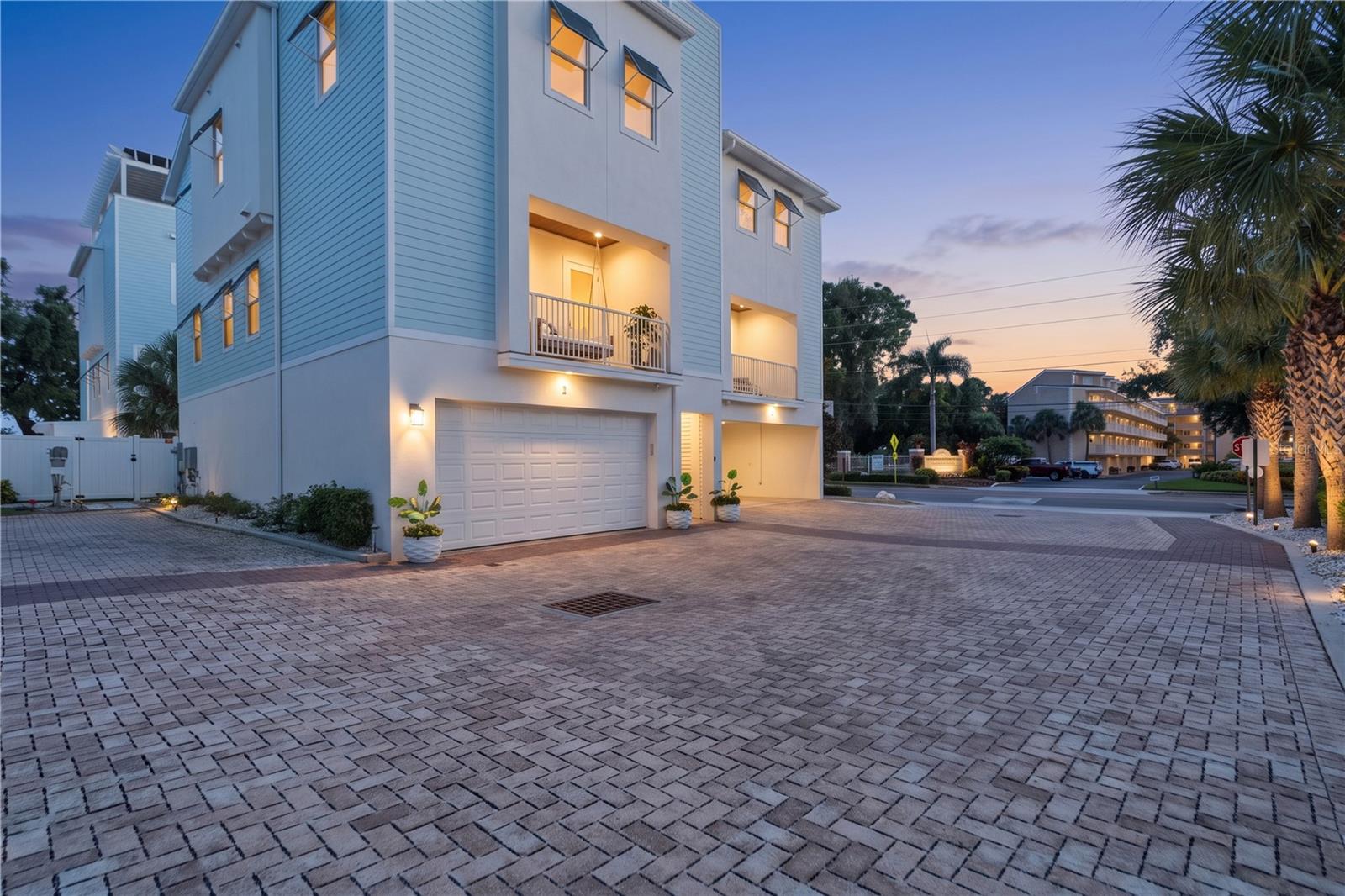 Gorgeous coastal living awaits in this newly built (2020), four-story Dunedin townhome. This intimate community features just 15 executive style homes, complete with a rooftop terrace showcasing panoramic views of the Gulf, Caladesi Island, and the intercoastal waterways. Flood insurance is not required. Offering 3 bedrooms, a dedicated office, 2.5 bathrooms, and a private four-stop elevator, this home combines thoughtful design with an exceptional location. Built with insulated concrete forms (ICF) for strength, energy efficiency, and sound reduction, the home also features Miami-Dade impact-rated windows and doors, Hardy siding, two balconies, and dedicated ADDITIONAL parking spots beside the unit. The front balcony includes a wood-paneled ceiling and a charming porch swing that conveys. Inside, the bright, open great room connects the living and dining areas to a well-appointed kitchen featuring shaker-style cabinetry with crown molding, granite countertops, a spacious pantry, a generous island with seating, and fully upgraded Samsung white-glass appliances. Other recent updates include a natural-stone backsplash and kitchen island. Wide-plank engineered wood flooring and abundant natural light create a relaxed modern-coastal feel. A dedicated office offers a quiet space for work or other hobbies. The spacious primary suite features a sitting area, walk-in closet, and en-suite bath with dual vanities, a soaking tub, and a separate shower. Two additional bedrooms—one with a Murphy bed and built-in desk—share a full bath. A convenient laundry closet includes a recently purchased LG front-load washer/dryer (2026) that convey. The four-car garage has a pebble-epoxy floor, two separate bays with dual garage doors, and a recently upgraded (2026) climate-controlled area currently set up as a home gym. Outdoors, the newly (2026) extended vinyl-fenced backyard offers a paver patio, low-maintenance turf, and attractive landscaping. The rooftop terrace is the home’s standout feature: an expansive fourth-floor retreat with 360-degree views, ideal for enjoying sunsets and coastal breezes. It’s accessible by both elevator and stairs. Located just steps from the Pinellas Trail, golf cart to downtown Dunedin’s restaurants, boutiques, and waterfront attractions, this townhome offers a distinctive blend of space, comfort, and coastal lifestyle