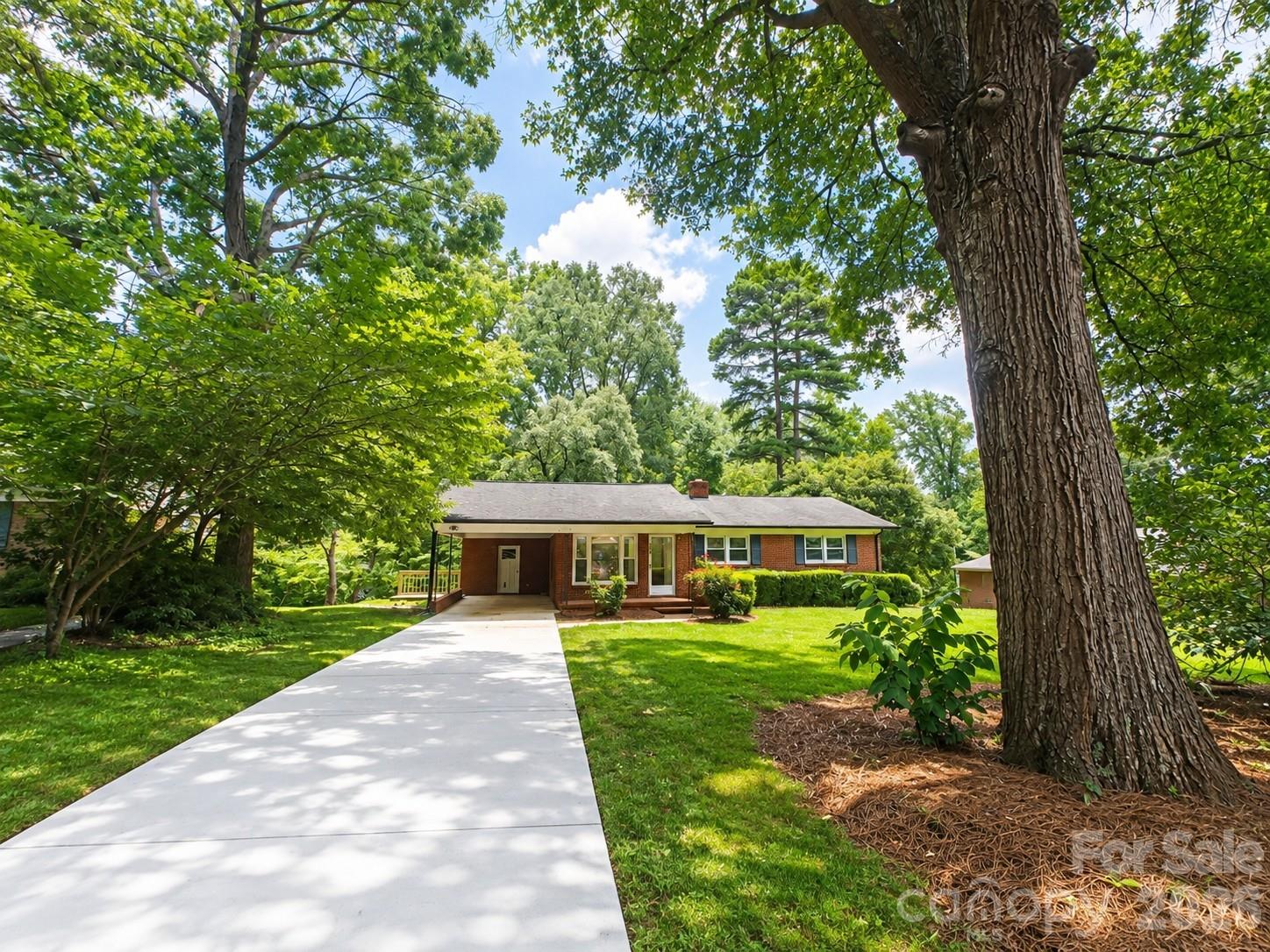 Brick ranch charmer in serene setting on tree-lined street on nearly half an acre! Aged trees surround the home and yard adding privacy and quiet enjoyment that welcomes you the minute you pull in the driveway. Attached carport, large utility room, walk out- unfinished basement ideal for storage, spacious front and back yard, updates throughout, new flooring with ideal color, new paint, gas cooktop, and more! Nice windows allow great lighting. Adorable kitchen! Spacious primary bedroom, gorgeous bathroom fully updated! Home is convenient to I85 and all of Gaston County! This doll house will not last! Call today for a showing.