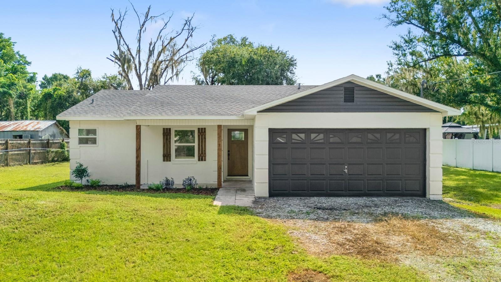 Welcome home to this beautifully renovated 3-bedroom, 2-bath home offering the perfect blend of modern updates, spacious living, and country charm! Step inside to find luxury vinyl plank flooring throughout, fresh interior paint, and a spacious kitchen featuring quartz countertops, stainless steel appliances, and an abundance of cabinet space.  The primary suite offers a walk-in closet and a beautifully updated bath with a walk-in tiled shower. Major improvements include a BRAND NEW ROOF AND AC, new windows, and fresh exterior paint giving you peace of mind for years to come.  Outside, enjoy nearly half an acre (.40 acres) of fully fenced property, providing plenty of room to spread out, entertain, garden, or simply enjoy the outdoors. A two-car garage provides additional parking and storage.  Enjoy the peaceful feel of country living while still being conveniently located close to town, restaurants, shopping, and I-4 for an easy commute. Beautifully updated, move-in ready, and offering the space you've been looking for—this one is a must-see!