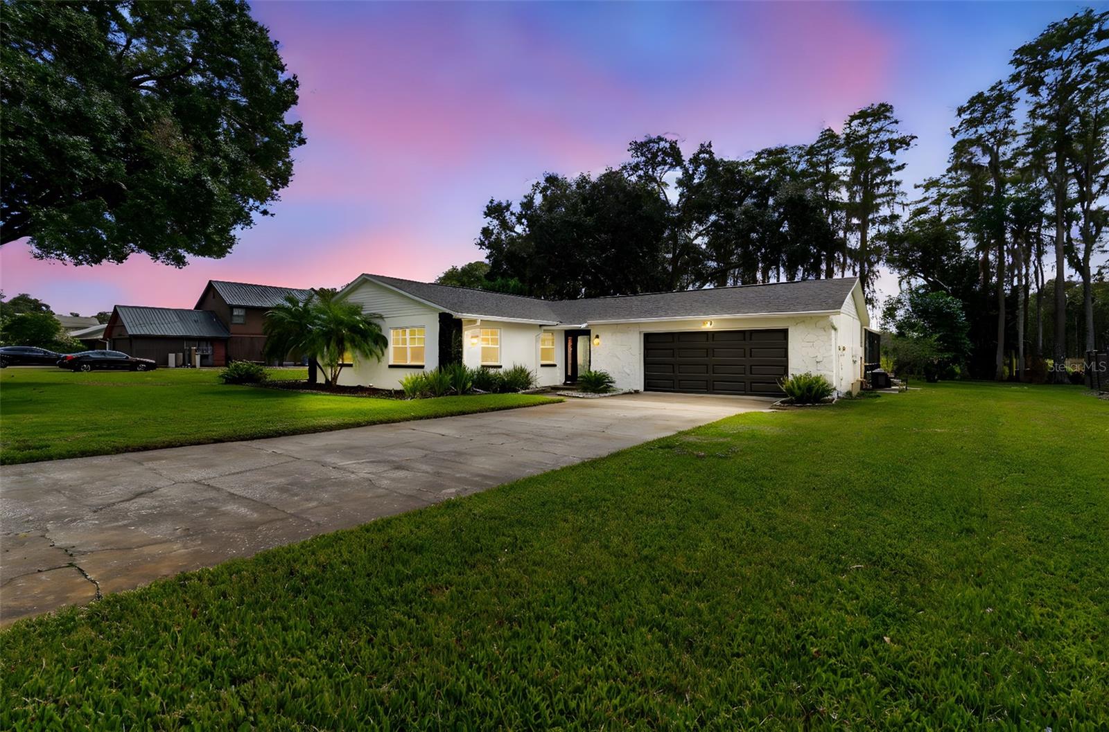 A property like this in Lutz does not hit the market often so don't miss out! LOCATION, LOCATION! Country Paradise without compromising location and modern conveniences. Almost 1 acre lot with no rear neighbors and a beautiful view to tall Cypress trees and a tranquil natural lake. The home has been renovated with new floors, NEW ROOF 2025, NEW HVAC 2025, Water Heater (2023), NEW STOVE 2025! The home has a clean and modern color palette throughout ready for you to move in. The kitchen is an open concept facing the living room and dining room. The kitchen has white cabinetry, pantry closet, stainless steel appliances, granite countertop, and a window to the pool. The garage was converted by previous owner with a laundry room, private dedicated space perfect for a home office, gym, storage, crafting room, or anything you desire. The living room has a wood burning fireplace perfect for ambiance and cooler days. The oversized Florida room adjacent to the living room is ideal for another living room area or recreational space. Step outside and nature will take your breath away! Enjoy the pool with no bugs as it has been screened in and extra pool deck to lounge. The home sits on the three lots making it approx. 150 feet wide! Grow your own vegetables with an onsite green house or use the space to build a mother-in-law house. Bring your boat, RV, work vehicles, 4 wheelers and more as the side of home can store all your toys! The home has a septic, well, Culligan water treatment, and a water softener. NO HOA restrictions. Near Lutz Preparatory (K-8), US 41, restaurants, shops, Tampa Premium Outlets, Shopps at Wiregrass, and more! Easy access to I-275, Tampa International Airport, Beaches, Busch Gardens, and more!