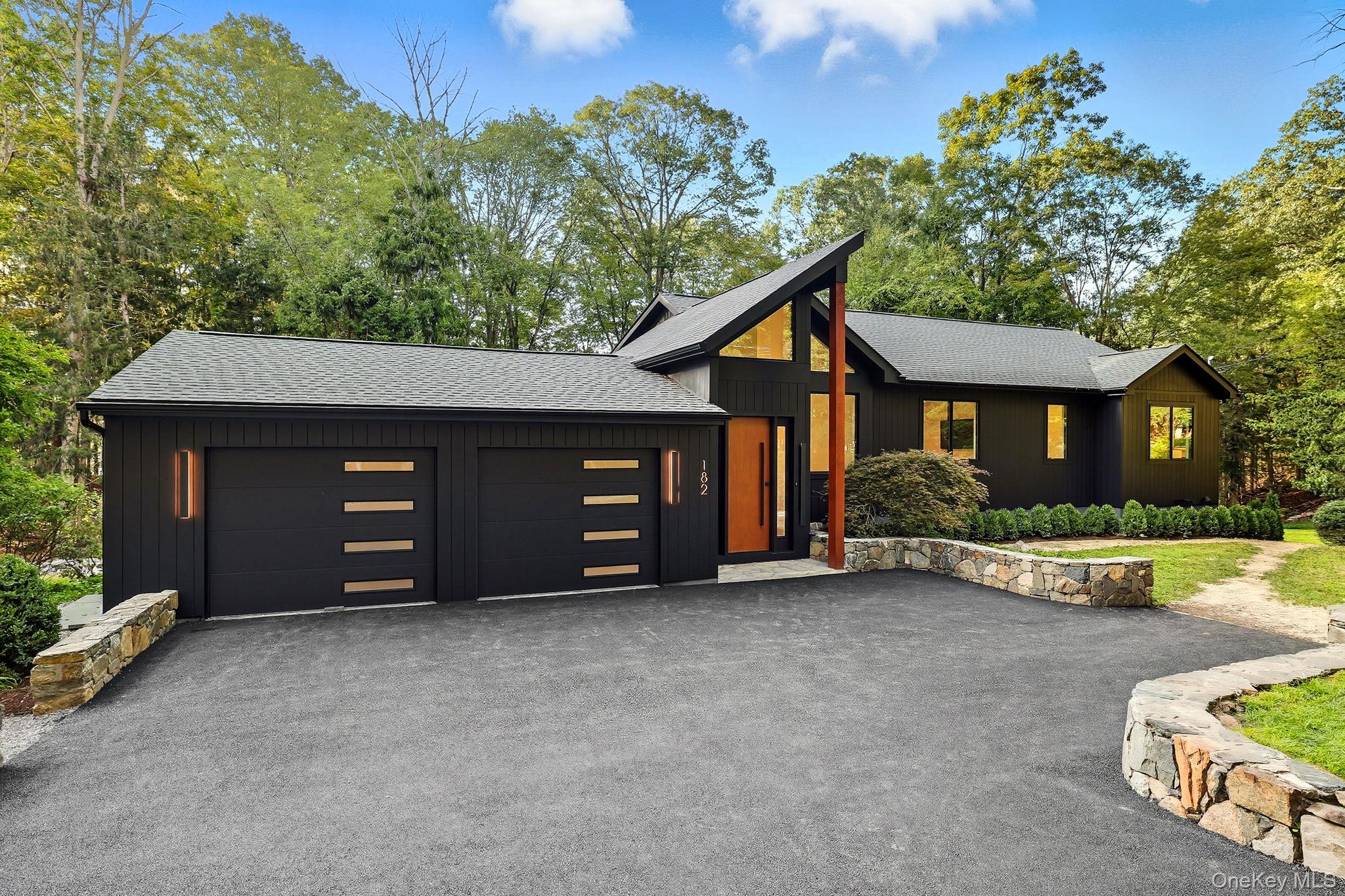 Welcome to the wonder of North Salem.
This extraordinary residence is where postmodern boldness meets mid-century serenity, completely reimagined in 2025. This chic home was fully rebuilt down to the studs. Set on 1.5 private acres—with two bonus acres of preserved land along the Titicus Reservoir—the home offers privacy, nature, and water views that unfold in every direction.
Driving up, the architecture makes an immediate impression—bold yet serene, masculine yet refined. Step inside and soaring ceilings, white oak plank floors, and floor-to-ceiling windows frame the ever-changing drama of the reservoir. In the expansive open-concept living room, a fireplace serves as the focal design point, wrapped in custom wood detailing that adds warmth and intimacy to the home’s grand scale.
The heart of the residence is its exquisite, oversized kitchen, a showpiece for entertaining. With marble countertops, top-tier professional appliances, and generous prep and storage space, it is equal parts functional and stunning—perfect for hosting friends or savoring quiet mornings with a view.
On the main level, the luxury primary suite feels like a retreat unto itself, complete with breathtaking reservoir vistas. A guest suite with en suite bath and a den/study complete the floor, offering comfort and flexibility.
The walk-out lower level is designed for gathering. A large entertaining room with wet bar creates the perfect hub for celebrations and game nights. There is also an additional bedroom, full bath, and laundry, as well as a spacious, light-filled bonus room with windows that frame nature and water views—ideal for a gym, studio, or creative space. Just beyond, the covered porch extends the living outdoors, offering a shaded retreat no matter the season. Imagine fall afternoons watching football with friends, a glass of wine in hand, or quiet evenings surrounded by the sounds of nature—all while protected from the elements.
Here, every season feels magical. Spring blossoms mirror across the water, autumn foliage blazes in reflection, winter snow turns the landscape into a private snow globe, and summer unfolds with barbecues and long evenings on the expansive Trex deck. A lush green lawn invites games and picnics, while a wooded private path leads down to the reservoir’s edge, where a fire pit and stargazing await.
An approved pool permit transfers with the property, offering the chance to craft a resort-like oasis. And beyond the acreage, North Salem’s celebrated backroads, farms, and restaurants are just moments away.
Vacation living, 365 days a year.
Whether as a weekend escape or full-time residence, this is a home designed to inspire, impress, and restore.