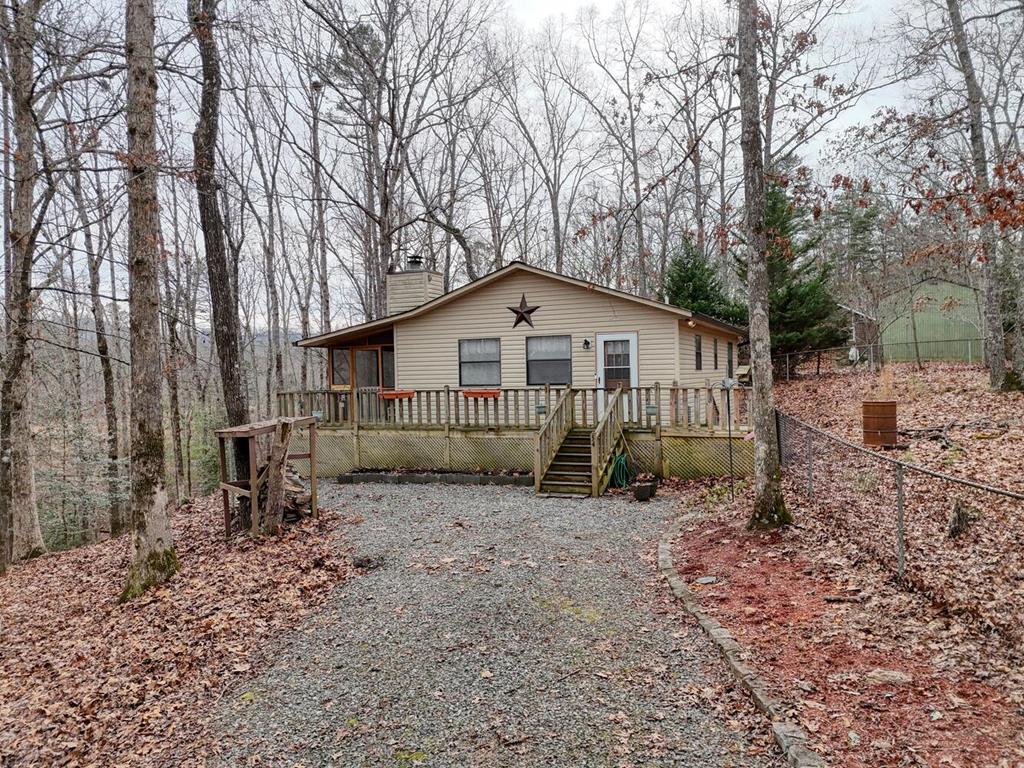 WELCOME HOME to this immaculate well-kept home nestled on beautifully wooded property with fenced yard. This cozy home features hardwood floors throughout, rock wood burning Fireplace, stainless steel appliances & granite countertops. Enjoy time on the covered porch for with seasonal mountain views and watching wildlife. This one has a convenient location with easy access to Murphy and Blairsville, paved road access making this property perfect for full time living or a vacation get away.