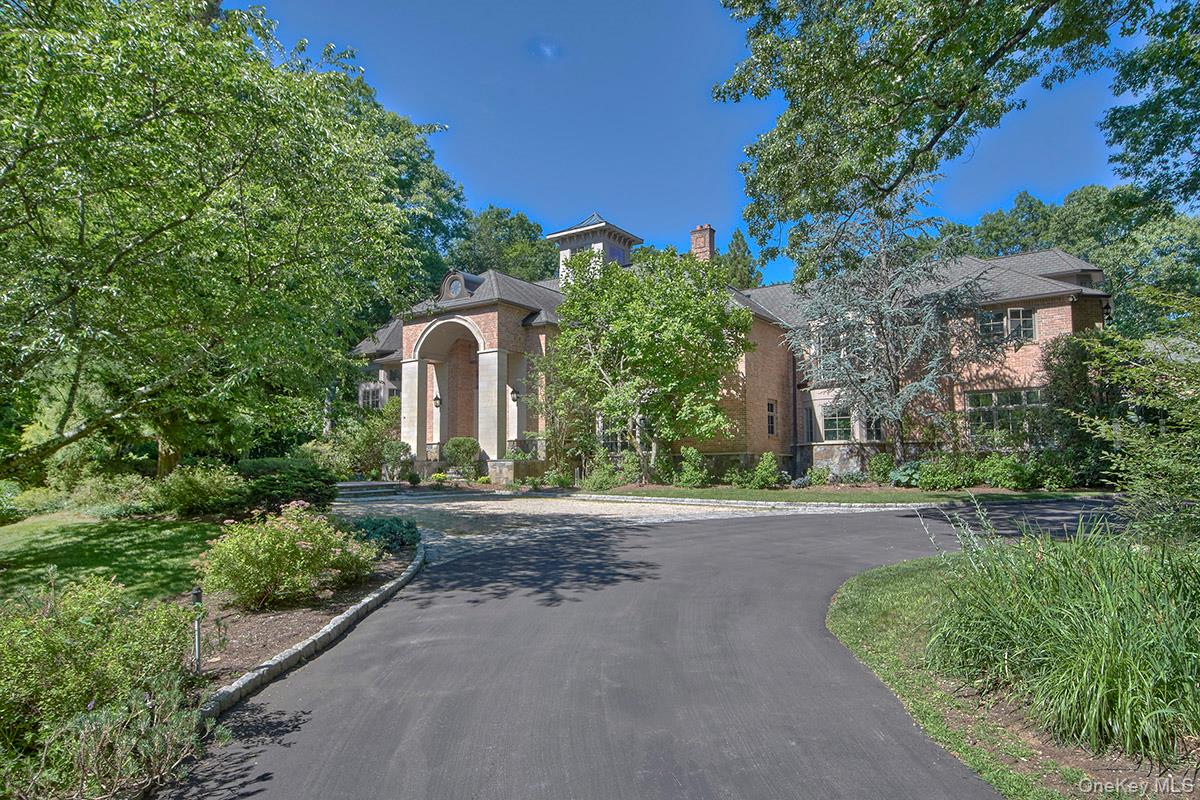 Timeless elegance meets exceptional craftsmanship in this spectacular brick and stone estate, privately set behind gates on 4+ acres in one of Chappaqua's prestigious Whippoorwill neighborhoods. Designed by acclaimed architect Carol Kurth and masterfully built in 2003 by renowned builder Robert Torre, this extraordinary 5-bedroom, 6 full, 1 half bath residence offers over 10,000 square feet of impeccably crafted living space, where timeless architecture, luxurious finishes, and modern comfort come together seamlessly. A long private drive leads to a grand arrival. Inside, a dramatic two-story foyer with a sweeping circular staircase sets the tone for the home's impressive scale and refined design. Every room features soaring 10-ft ceilings, while the entry foyer and formal living room rise to over 20 feet, filling the home with light and volume. Rich hardwood floors, exquisite custom millwork, recessed lighting, and four fireplaces enhance the warmth and sophistication throughout. Designed for both grand entertaining and comfortable everyday living, the main level flows effortlessly from room to room. A spectacular formal living room with walls of windows opens to a gracious dining room, while the designer chef's kitchen features custom cabinetry, honed natural limestone floors, an oversized island with seating, breakfast area, abundant prep space, and premium stainless appliances including a 48" Wolf range, 30" Wolf convection oven, Thermador microwave, separate 36" Sub-Zero refrigerator and freezer, and 2 Bosch dishwashers. A butler's pantry enhances entertaining, and French doors lead to an expansive stone terrace overlooking the pool and grounds. Adjacent to the kitchen, the family room is anchored by a striking stone fireplace. The 1st floor also includes a spacious guest suite with a private bath, a back hall with pool bath, and access to the heated epoxy-finished three-car garage with room for up to five vehicles using lifts—a dream for the automobile enthusiast. Between 1st and 2nd floors is a private office and below a wine tasting room. The luxurious primary suite offers a dressing room, two oversized walk-in closets, a private balcony overlooking the backyard, and a spa-inspired bath with radiant heated floors, whirlpool tub, and steam shower. Three additional en-suite bedrooms, an expansive recreation room, and a 2nd floor laundry complete the upper level, while an additional 1st floor laundry room adds convenience. An enormous unfinished lower level offers exceptional potential for a home theater, fitness center, wine cellar, golf simulator, or additional recreation space. The outdoor setting is equally impressive. Beautifully landscaped grounds designed by acclaimed landscape architect Louis Fusco feature sprawling level lawns, specimen plantings, curated gardens, classic stone walls, and a magnificent Cardillo saltwater pool with a new filtration system and electric safety cover. An expansive stone patio and charming gazebo provide exceptional spaces for entertaining and relaxation. Bordering the Glazier Arboretum and backing to forever protected land, the property enjoys extraordinary privacy, tranquility, and picturesque natural surroundings. Additional amenities include a whole-house generator, electric vehicle charger, Elan smart home system for lighting, thermostats, and security. Just minutes from downtown Chappaqua, award-winning schools, and Metro-North for an approximately 50- minute commute to Manhattan, this remarkable Whippoorwill estate represents a rare opportunity to own one of Chappaqua's premier luxury properties.