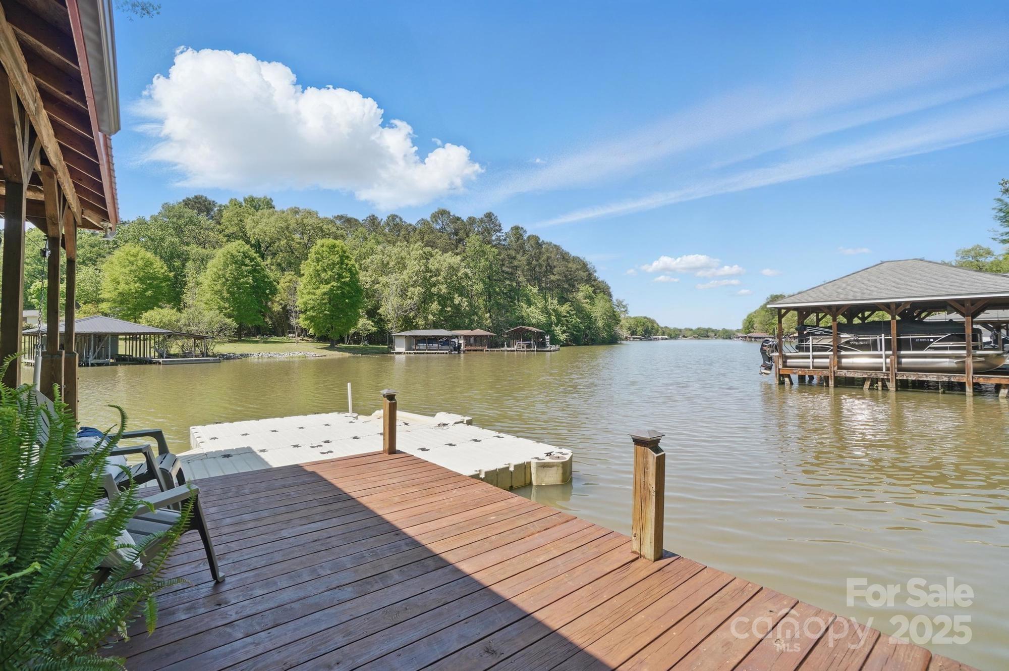 Welcome to 9711 Pine Tree Road in Norwood on beautiful Lake Tillery! This charming lakefront home offers peaceful cove views and endless spaces to relax and unwind. The boathouse features a large 2-slip dock, storage room, floating pier, and two areas perfect for lounging or fishing. Inside, enjoy a cozy family room with water views, a spacious deck, kitchen and dining area, and a main-level primary suite. Upstairs offers a large bedroom and flex room, while the basement provides a huge bonus space and full bath. Plus, an oversized detached garage is perfect for all your lake toys. Large lot for enjoying the outdoors.  Don’t miss this lakeside gem!

The home is a two bedroom, the home has other rooms the sellers have used as a bedroom.

This home is perfect for a large family that loves lake life!  It would also make a great rental.

You must come take a look at  this gorgeous home on Lake Tillery.  New buyer would need to apply for water lease. with Duke Power.