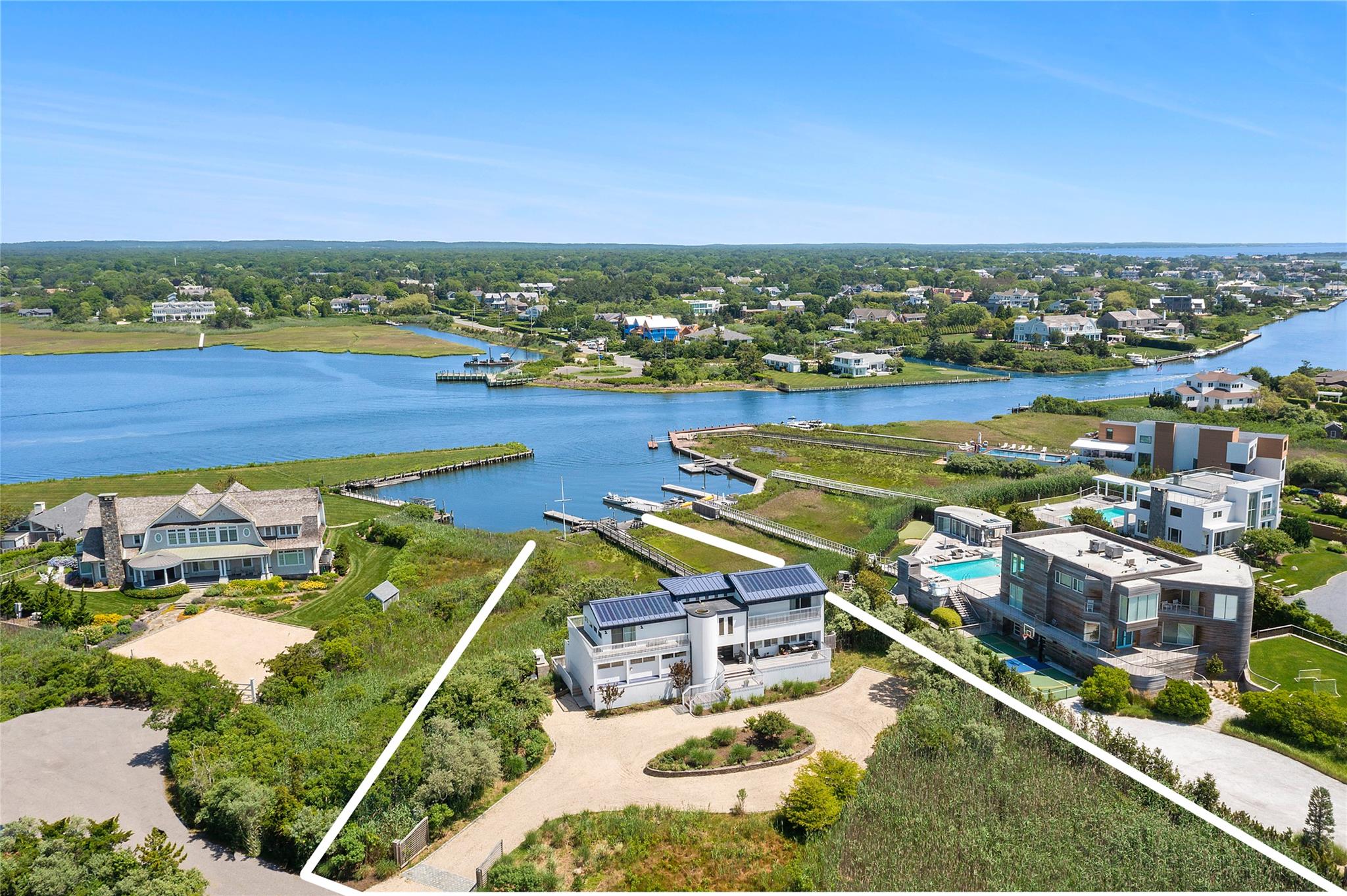 Located on a quiet street off Dune Road in prestigious Quogue, this distinctive four-bedroom, four-bath beach house offers an idyllic waterfront lifestyle. Boaters will appreciate the private deep-water dock set within a tranquil cove on Quantuck Bay, providing direct access for endless days on the water. A deeded private right of way to the ocean across the street ensures easy enjoyment of sandy shores and coastal breezes.

The home is thoughtfully designed to showcase panoramic bay views from nearly every room. Spacious decks extend from each living space, while the updated kitchen and open living room feature expansive sliding doors that seamlessly connect to the in-ground pool and dockside patio—perfect for entertaining or quiet relaxation. Upstairs, a sunlit den with floor-to-ceiling windows serves as a serene retreat, and two generous primary suites include walk-in closets and luxurious en suite baths.

Modern upgrades enhance both comfort and sustainability, including new bathrooms and kitchen finishes, solar panel metal roofing, and an energy-efficient geothermal heating and cooling system. Blending contemporary updates with classic Hamptons style, this property captures the best of indoor-outdoor living in a truly coveted Quogue location.
