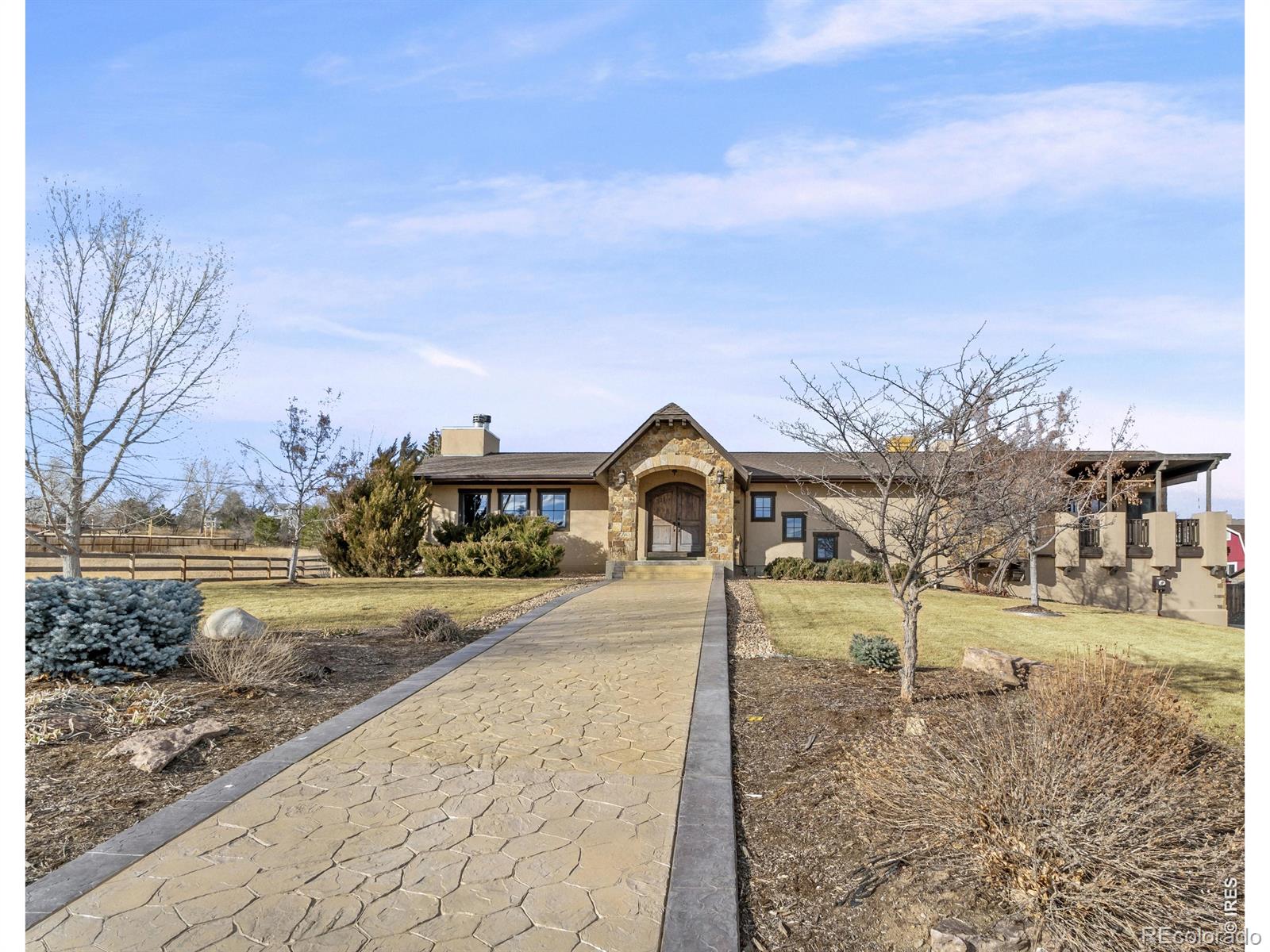 Are you searching for a spacious, separate professional workshop without sacrificing a beautiful home on the same property? This is the one. Situated on a one-acre parcel, the custom ranch home, renovated in 2010, features 3,856 sq ft with 5 bedrooms, 3 baths, and an oversized 696 sq ft 3-car garage. Custom arched Alderwood doors, walnut hardwood floors, travertine tile, wrought iron accents, and thoughtfully designed cabinetry highlight the craftsmanship throughout. The main level includes a gourmet kitchen, open great room with cathedral and vaulted ceilings, dining area, primary en suite with a private covered deck, two additional bedrooms, laundry, and storage. Three fireplaces enhance the great room, primary suite, and lower-level media room. The lower level offers ideal entertaining space with a media room, kitchenette (dishwasher and refrigerator), two bedrooms, full bath, storage, and garage access. The oversized garage includes extensive built-in cabinetry. The 2,000 sq ft free-standing workshop (built 2023) is a standout feature. Constructed with metal siding and an 8" thick 4,000 PSI reinforced concrete floor (#6 rebar on 10" centers), including two 12' x 14' doors for large vehicles and equipment. Outfitted with BendPak lifts (18,000 lb 2-post and movable 9,000 lb 4-post), new washer and dryer, toilet and urinal with rough-in shower, utility sink plus parts washer, extensive built-in workbench, Rinnai tankless gas water heater, gas wood stove/heater, and Porta-Cool evaporative cooler. Additional 20' storage container and approximately 7,000 sq ft of gravel parking/storage area complete this exceptional property. A rare blend of luxury living and high-performance workspace. Original structure was built in 1963 with a rebuild in 2010, according to seller