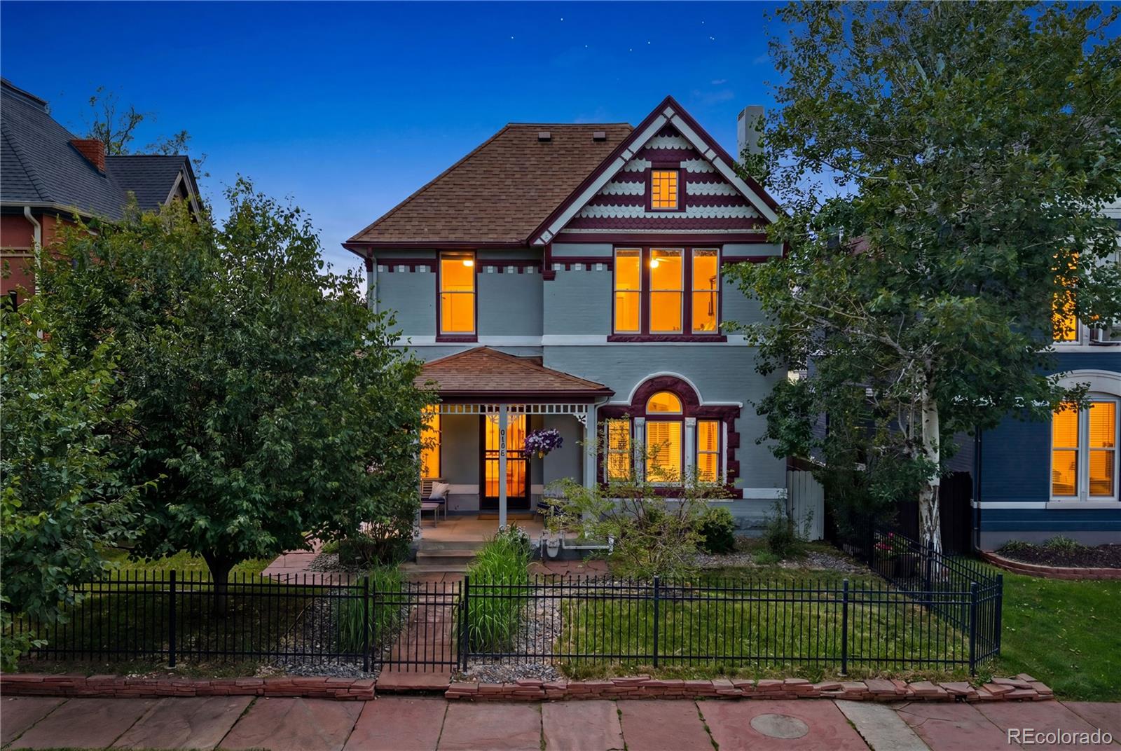 Own a remarkable piece of Denver history in the heart of City Park West. Built in 1893, this stately Victorian masterpiece seamlessly blends timeless architectural character with modern luxury, offering an extraordinary main residence, a fully finished carriage house ADU, and a detached gym and sauna retreat. From the moment you arrive, the beautifully restored Victorian-era porch sets the stage for the elegance & charm found throughout. Original details abound, including antique doorknobs, hinges, fireplaces, arched entryways, corbels, and intricate craftsmanship. Thoughtful updates complement the home's historic soul. The recently updated gourmet kitchen is a chef’s dream, featuring premium stainless steel appliances, a Jenn-Air professional 6-burner range, and three ovens. Host memorable gatherings in the elegant dining room, which opens seamlessly to the covered patio. The spacious living room is ideal for entertaining & showcases one of two original fireplaces. All bedrooms are generously sized, including two with stunning Denver skyline views and one with its own rooftop deck. The third floor serves as a private retreat. Three full bathrooms blend vintage elegance with modern comfort, including two featuring antique bathtubs. A hidden bookshelf reveals one of the home's most unforgettable features—a secret speakeasy-style basement complete with exposed brick and a wet bar, creating the perfect space for entertaining. The charming backyard has a flagstone patio to ADU & gym, and a covered deck with wood-plank ceilings. Beyond the main home, the fully finished one-bedroom, one-bath carriage house offers exceptional flexibility for guests, rental income, or Airbnb opportunities. A detached gym and sauna complete this truly one-of-a-kind property. Chosen as one of 5280 Magazine’s best neighborhoods, City Park West offers vibrant city living, beautiful historic architecture, & unbeatable access to Denver’s parks, restaurants, culture, & entertainment.