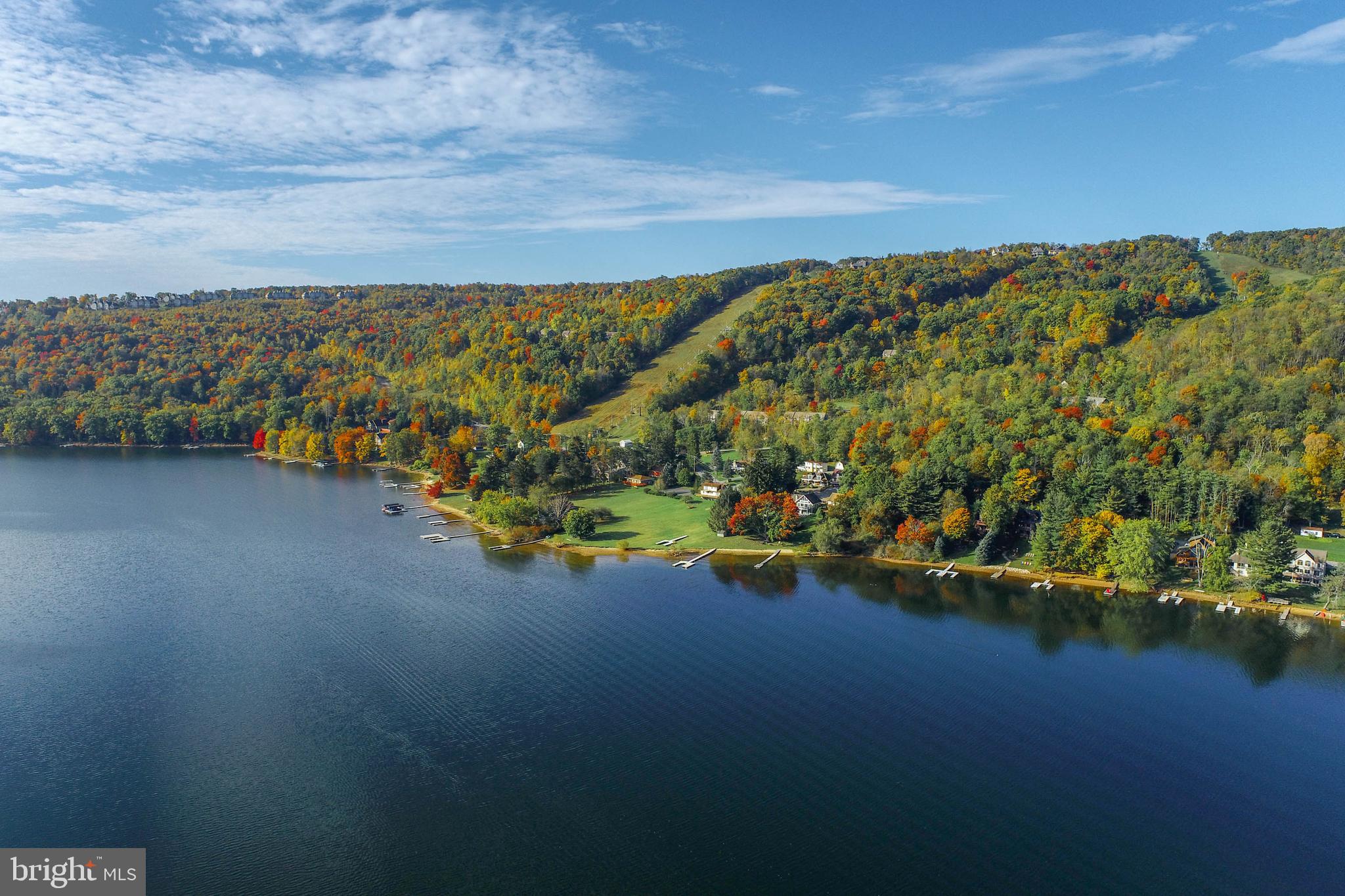 Discover a rare opportunity to own 180 feet of prime Deep Creek Lake frontage along the highly sought-after Marsh Hill Road, just steps from the year-round recreation of Wisp Resort. This unique lakefront property offers incredible flexibility, whether you're looking to build a private estate or develop multiple homes,. The parcel can be utilized as three separate 60-foot building lots, each with its own single-slip Type A dock permit—perfect for individual vacation homes or resale. Alternatively, combine into two 90-foot lots with unrestricted Type A dock permits for larger lakefront retreats, or retain the full 180 feet for an expansive dream home with panoramic water views and ample space for outdoor living.Adding to its value, the property also includes a quarter-acre lot directly across Marsh Hill Road, ideal for constructing a guest house, carriage home, or additional garage space. With a mostly level approach to the water, utility access at the street, and unmatched proximity to skiing, golf, marinas, and restaurants, this offering combines convenience, natural beauty, and development potential. Whether you're a builder, investor, or dream-home buyer, this is a once-in-a-generation chance to secure premier shoreline on Deep Creek Lake within close proximity to Wisp Resort. Don’t miss out—properties of this caliber are rarely available.Parcels are also available for sale separately.
