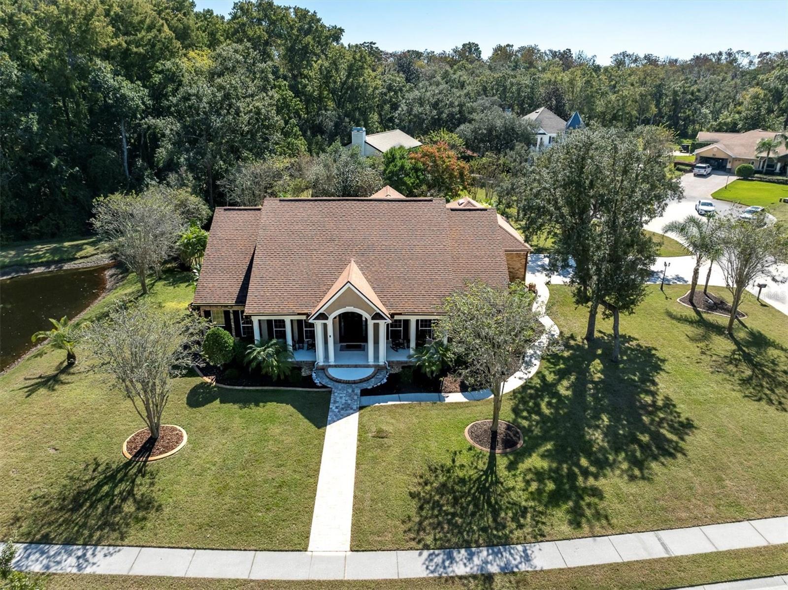Welcome home to 11602 Lakeview Drive, where timeless Cape Cod charm meets modern Florida living.Tucked behind the gates of The Reserve at Golden Acres, this beautifully updated 4-bedroom, 4-bath pool home with loft and bonus room spans 3,288 square feet and sits on 1.34 acres of a corner homesite in a Cul-de-sac surrounded by mature trees, privacy landscaping, and peaceful pond views. Every detail has been thoughtfully designed, creating a move-in-ready sanctuary perfect for both everyday living and effortless entertaining. The heart of the home showcases soaring vaulted ceilings, designer chandeliers, and a cozy gas fireplace with remote start, while abundant natural light fills the space through tall windows. The open-concept layout seamlessly connects the main living areas, leading to a stylish and functional kitchen with newly refaced cabinetry, KitchenAid stainless steel appliances, a dual-range oven, convection microwave, built in storage, and plenty of gathering space, including an eat-in bar that seats up to 6 and room for a kitchen table perfect for enjoying your morning coffee. Just off the living area, the primary bedroom suite feels like a true retreat. French doors open to a private sitting room or home office complete with a wet bar. The remodeled ensuite bath features a freestanding soaking tub, dual vanities, dual custom closets, built in safe, and a walk-in shower with bench that evokes a spa experience. Three additional bedrooms, plus a spacious upstairs loft and flex room provide plenty of options for guests, hobbies, work-from-home, or multi-generational living. Step outside to your Florida paradise. The screened lanai includes updated pavers, a sparkling pool with an updated salt system, updated pool pump (2024), a wall-mounted TV, and a covered lounge area perfect for relaxing or entertaining. Beyond the lanai, a walkway with pavers leads to an outdoor patio with a fire pit, creating the ideal spot for cozy evenings under the stars. The property offers just the right blend of open space and privacy, surrounded by manicured landscaping and a peaceful sense of calm rarely found in traditional neighborhoods. Nearly every part of this home has been refreshed or upgraded (too many upgrades to list!), including engineered hardwood flooring and new carpet, custom closets, updated bathrooms, landscape lighting, indoor lighting, and fixtures. Additional improvements include newer AC systems and ducts (2023) with UV light (2024), an updated water heater (2023) and softener (2024), irrigation system replacement (2024), Sherwin-Williams designer paint, sealed pavers, complete landscape enhancements with decorative curbing, plus so much more! With public utilities, a three-car oversized garage with utility sink and storage shelving, low HOA fees, and no flood insurance required, this home is as practical as it is beautiful. Nestled in one of New Port Richey’s most desirable gated communities, you’ll enjoy privacy and tranquility with the convenience of nearby shopping, dining, top-rated schools, airports, and coastal recreation, all within minutes of major highways for easy commuting.If you’ve been searching for a move-in ready pool home in a gated community with space to spread out and countless modern updates, this is the one. Experience refined living with every comfort imaginable. This isn’t just a home; it’s your lifestyle upgrade waiting to happen. Copy and paste to your browser to see more: https://bit.ly/11602Lakeview