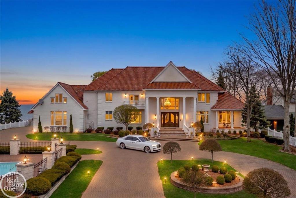 Welcome to an unparalleled lakefront estate offering 150 feet of breathtaking water frontage and over 6,500 sq ft of pure luxury living. Rebuilt from the foundation up in 2005, this magnificent 5-bedroom, 6 full & 1 half bath masterpiece was crafted with only the finest custom materials and unwavering attention to detail. From the moment you arrive, the gated entry, brick paver driveway, and generational baked clay roof signal that something truly extraordinary awaits. Step inside to a breathtaking dual staircase that sets the tone for the grandeur found throughout. Water views greet you from every room, with most windows soaring floor-to-ceiling. The main floor is finished in rich porcelain tile and designed for both everyday living and grand-scale entertaining. The chef's kitchen features a massive center island with secondary sink, gas cooktop, SubZero refrigerator, double oven, warming drawer, walk-in pantry, and custom cabinetry throughout. A two-way fireplace is shared with the living room. The formal dining room includes an adjacent wet bar with beverage cooler, separate ice maker, and glass sink. A second living room with a natural fireplace overlooks the water. The main floor also offers an office/library with French doors, a bedroom with private bath and sitting area, main floor laundry, and a stunning powder room. All bedrooms are generously sized with private en-suite baths and custom built-in closets. The primary suite is extraordinary, featuring a gas fireplace, sitting area, walkout tiled balcony with lake views, his & hers WICs with built-ins and laundry, and an attached private office. The spa-worthy primary bath showcases a Jacuzzi tub, tiled shower, his & hers sinks, and bidet toilet. The finished walkout basement adds 3,500 sq ft featuring a full second kitchen, bar, fireplace, home theater, workout room, living room, dining room, full bath, and two storage rooms, ideal for guests or multi-generational living. Laundry on all three levels. Outside, the inground pool with diving board and slide